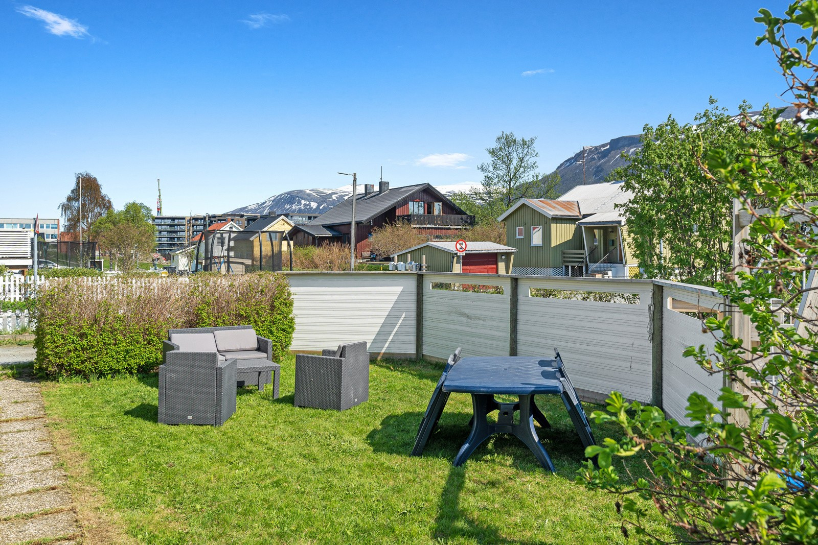 Koselig og skjermet uteareal med grønn plen.