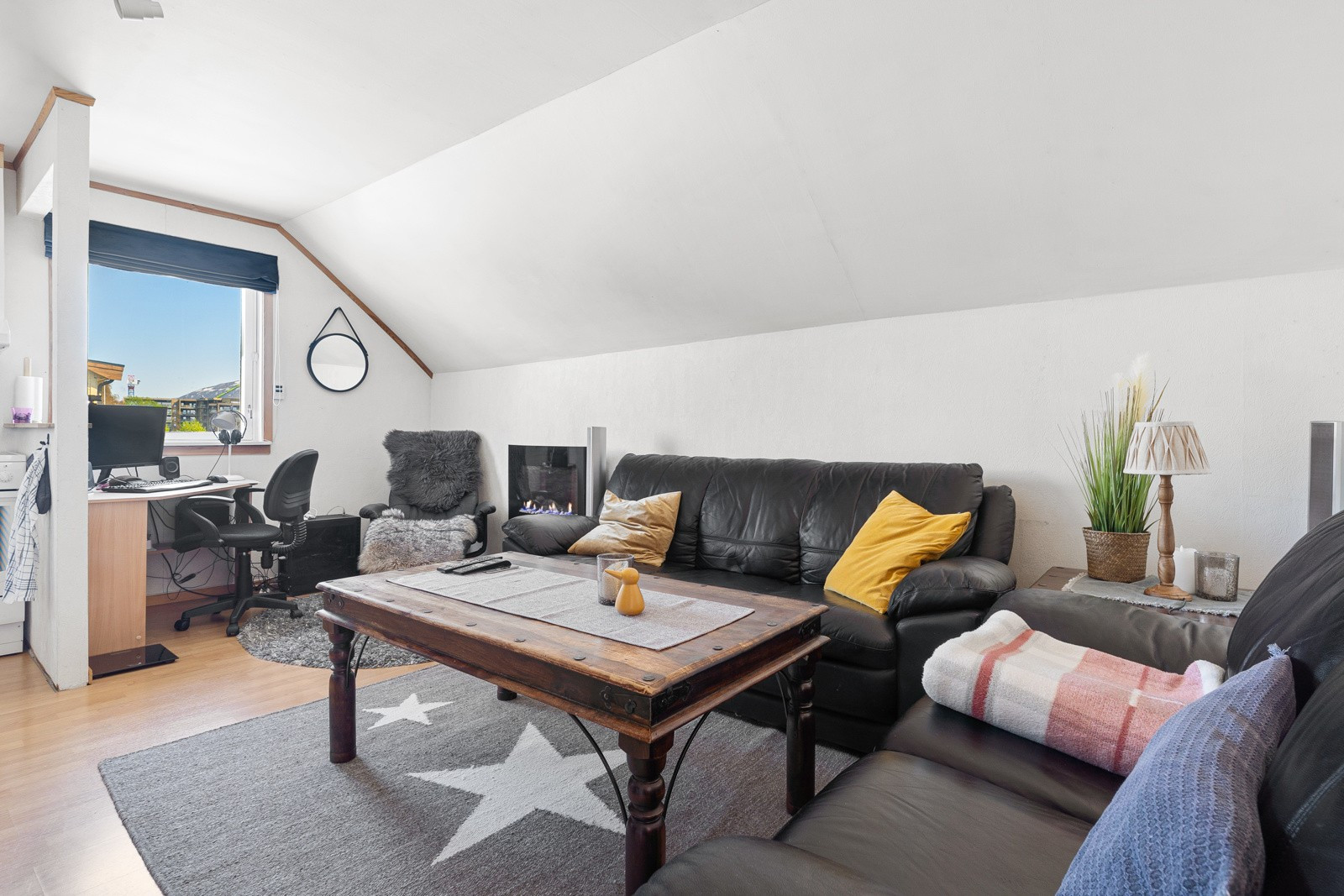Stuen på loftet har skråtak, men fortsatt plass til stor sofa og annet tilbehør.