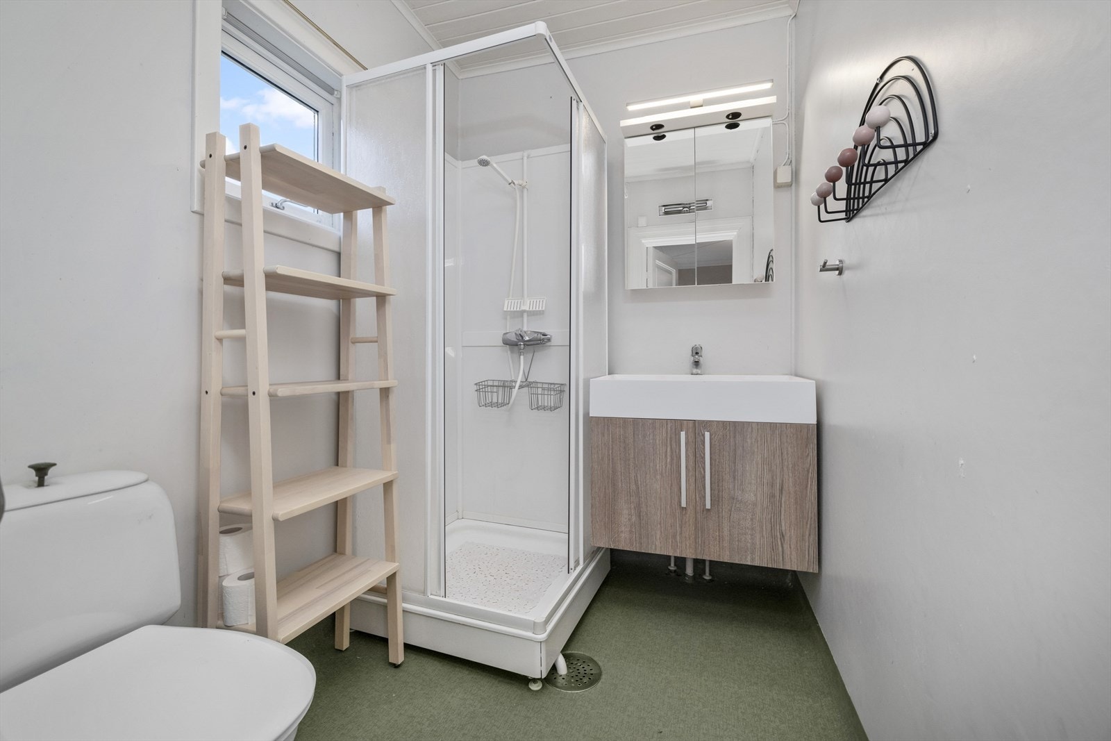 Badet er innredet med dusjkabinett, toalett og servant. Galleribilde