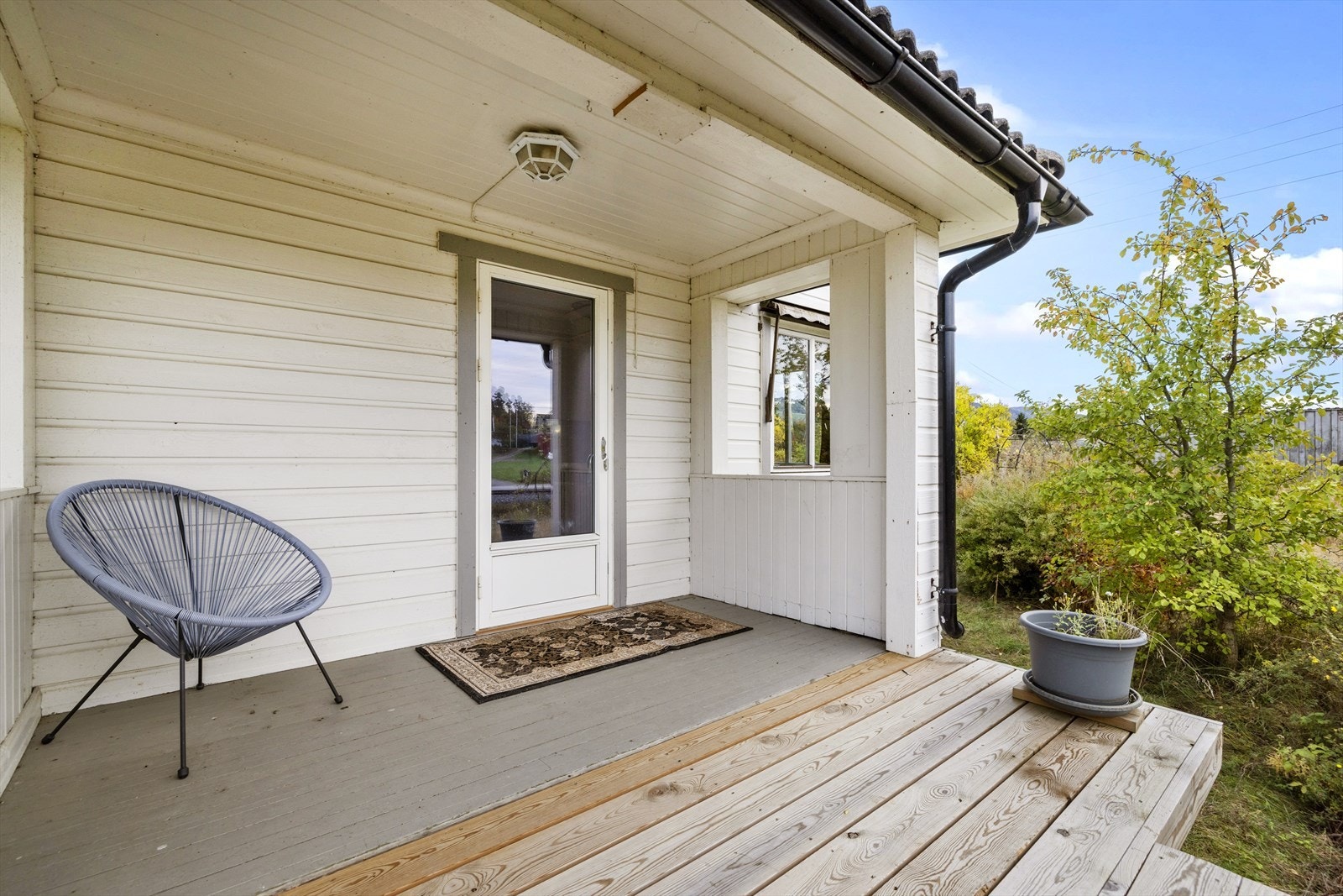 Overbygget inngangsparti med plass for utemøblement. Galleribilde