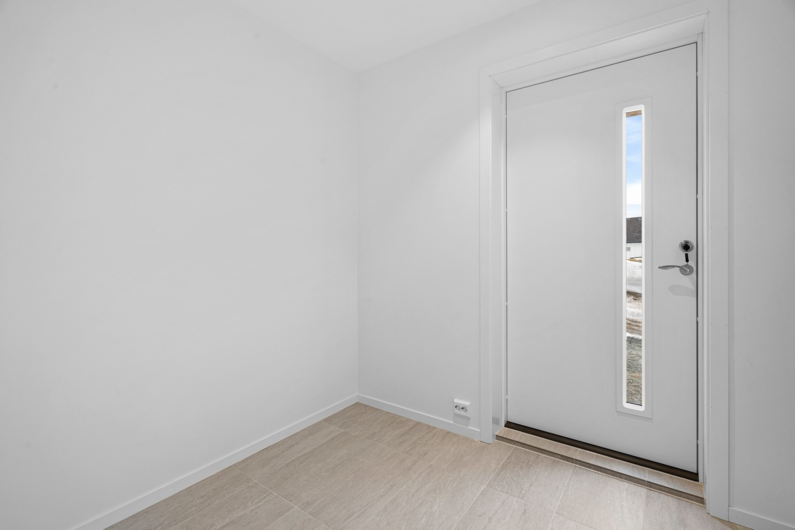 Romslig flislagt gang med god plass til skyvedørsgarderobe