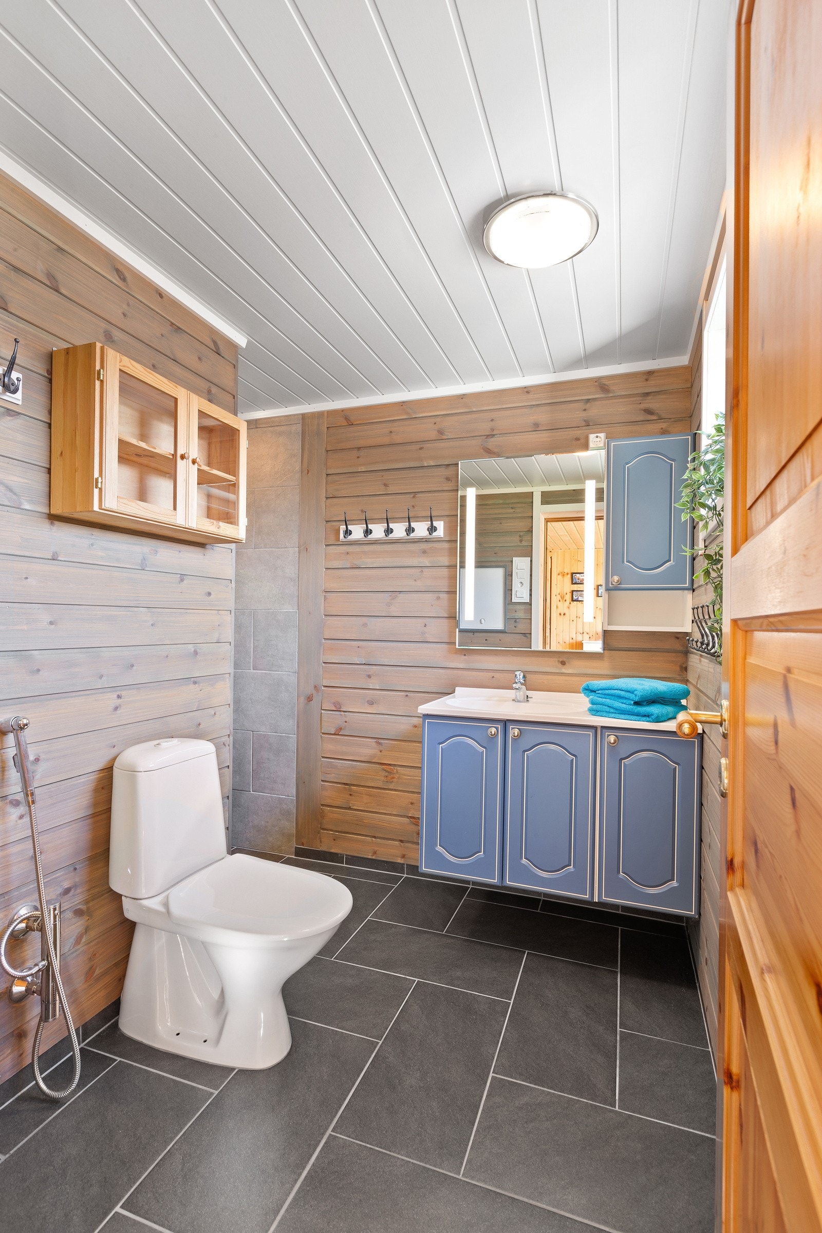 Baderom med flislagte gulv med varmekabler. Badet har toalett, dusj og servant med skap. Galleribilde
