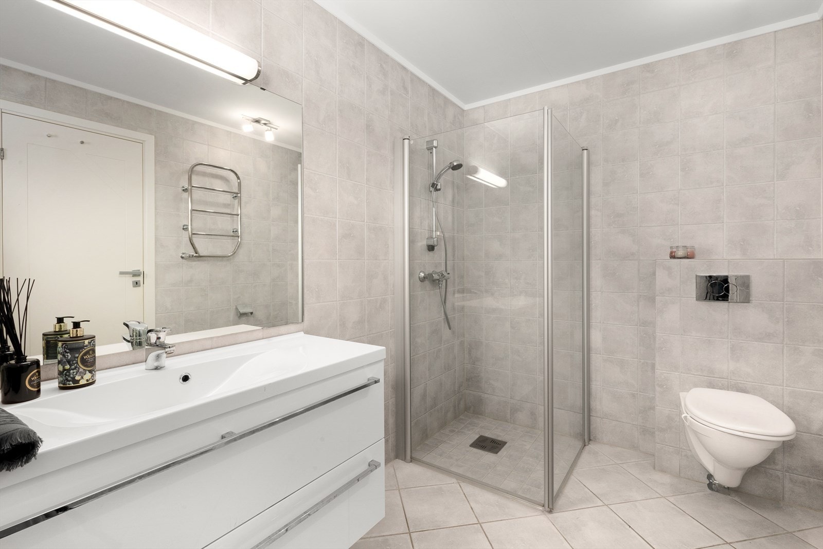 Det største badet ligger tilknyttet hovedsoverommet og gir et pent inntrykk med hvit, stilren innredning. Galleribilde