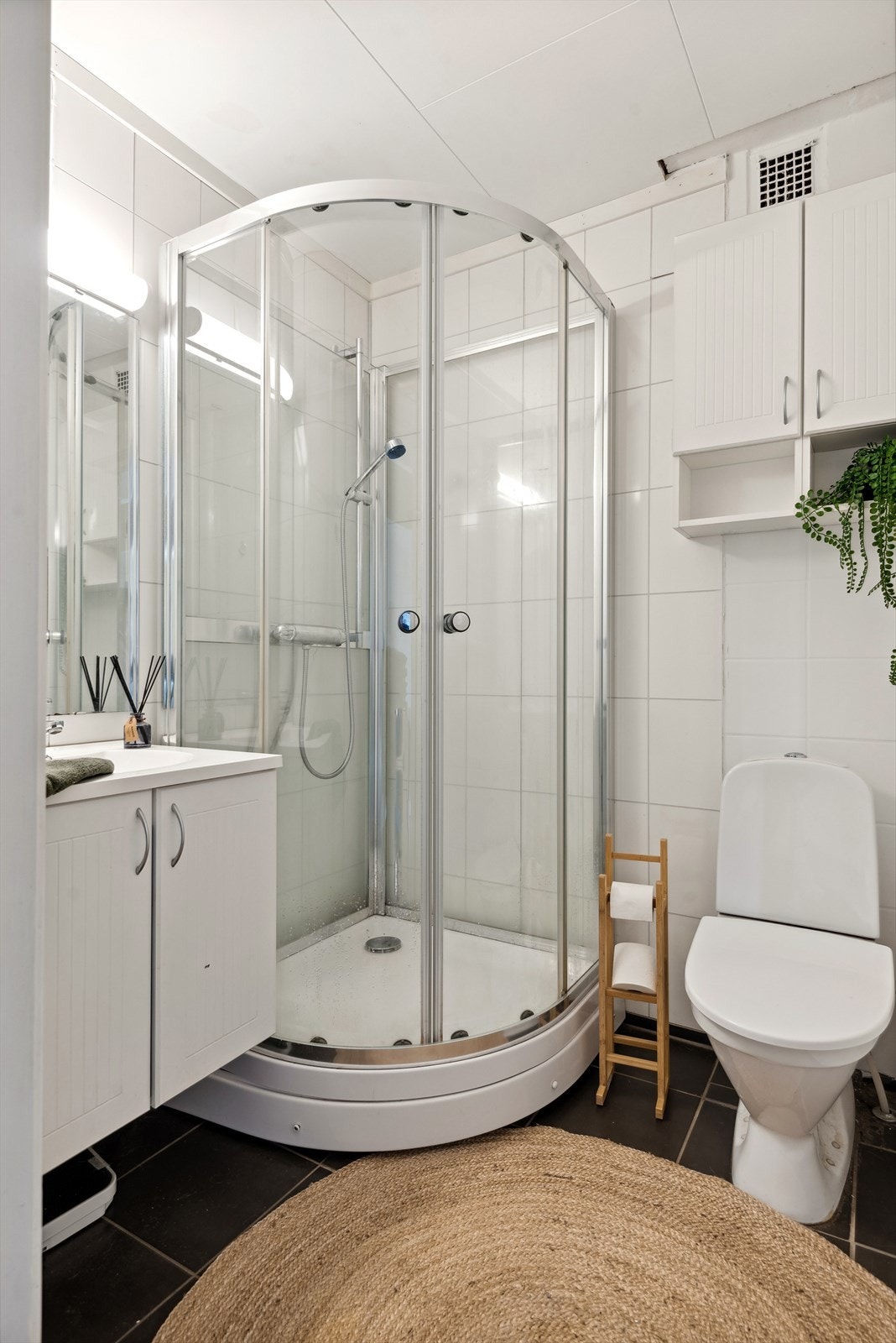 Baderommet i 1. etasje er et lyst og tidløst baderom som i følge tidligere salgsprospekt ble pusset opp i 2010. Baderommet har mørke fliser på gulv og overflater med lyse baderomsplater og del med fliser. Galleribilde