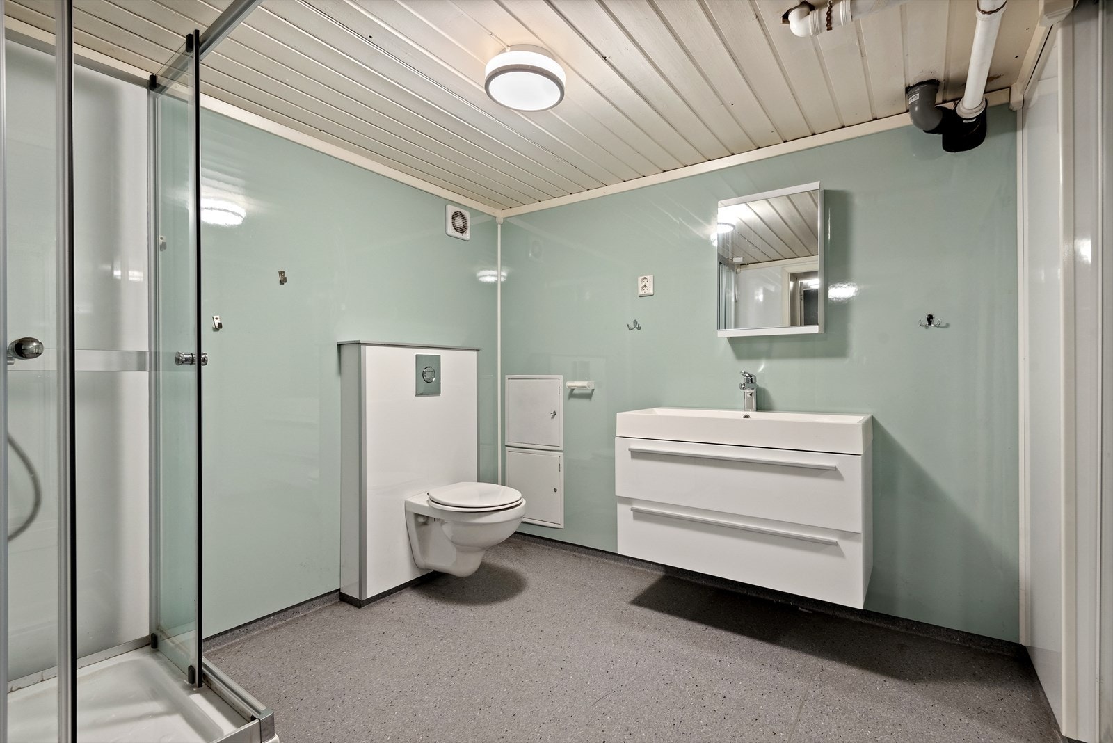 Boligen har også et stort og lyst bad/vaskerom i underetasjen som ble pusset opp i ca. 2017. Baderommet har grått våtromsbelegg på gulv med gulvvarme, våtromsplater på veggene og elektrisk styrt vifte. Galleribilde