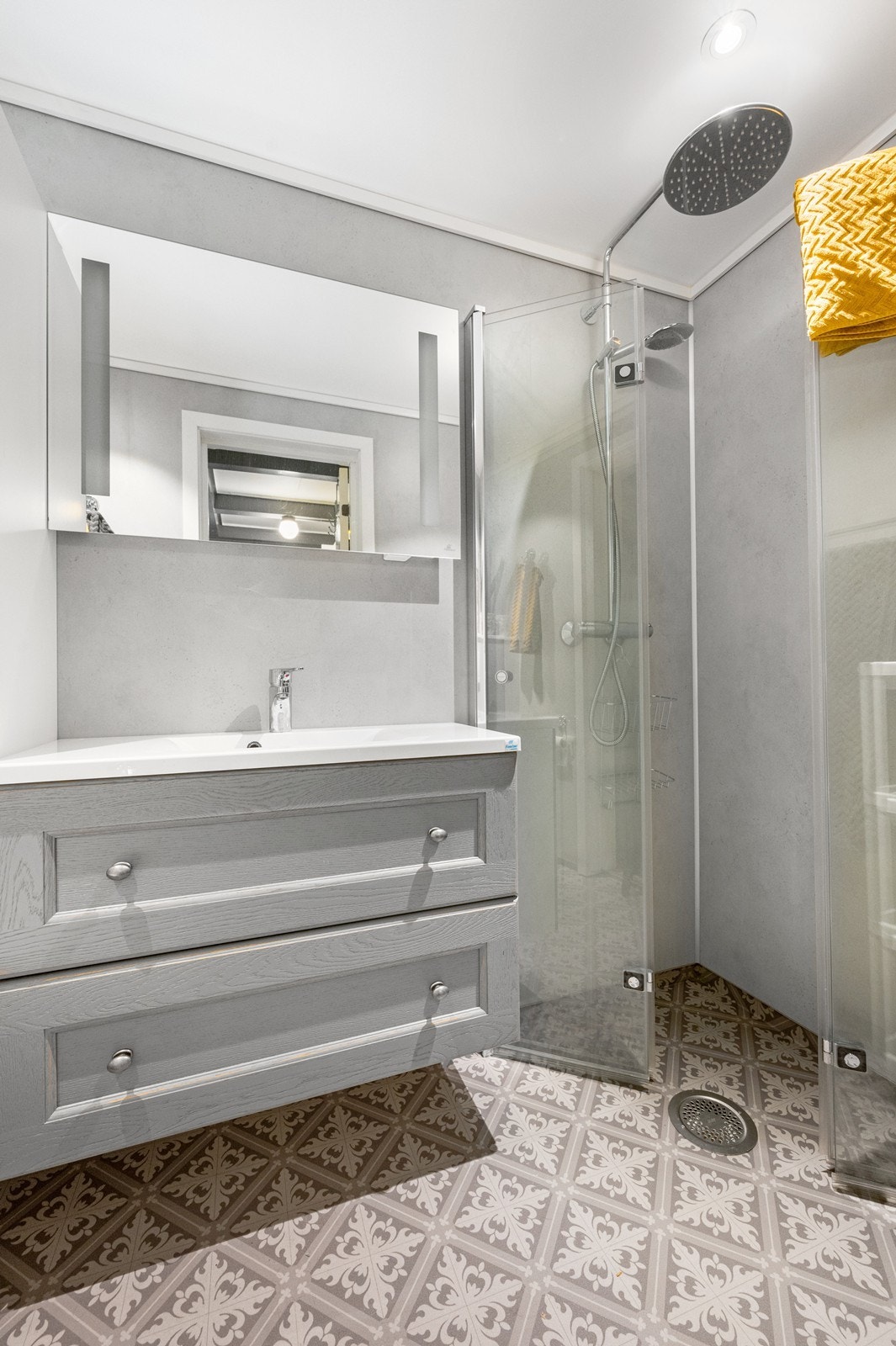 Heldekkende servantplate. Høyskap på siden, dusjnisje og veggmontert toalett Galleribilde