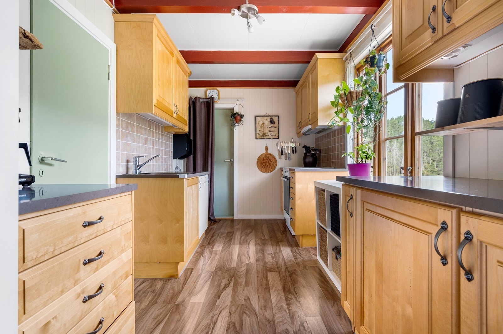 Kjøkkeninnredning i bøk utseende med over- og underskap i profilerte fronter Galleribilde