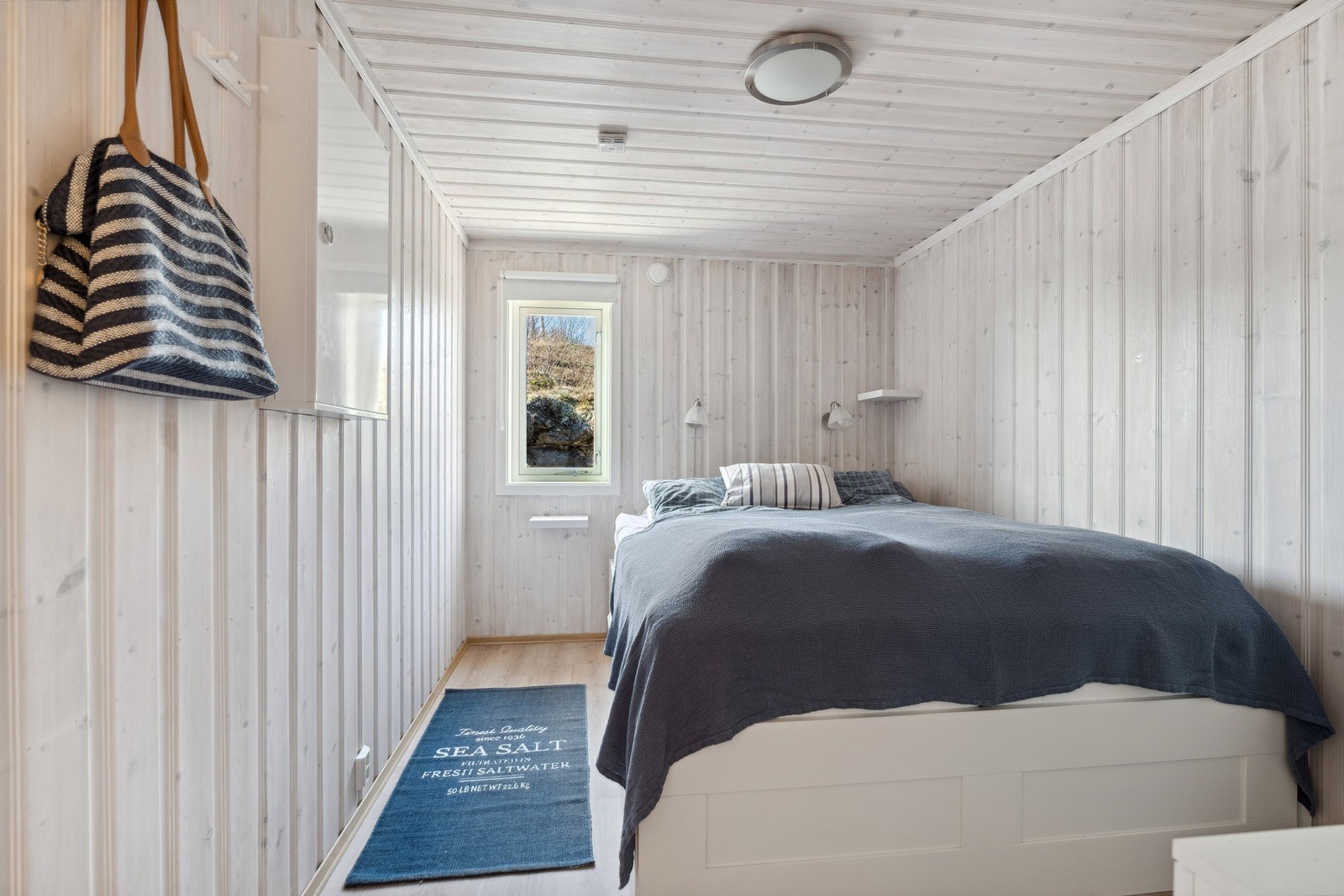 Soverom med laminat på gulv og beiset panel på vegger og tak. Galleribilde