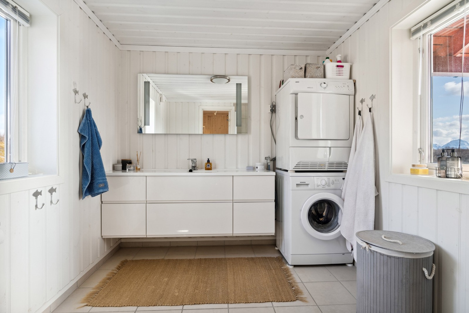 Bad med fliser på gulv med gulvvarme og malt panel på vegger. Galleribilde