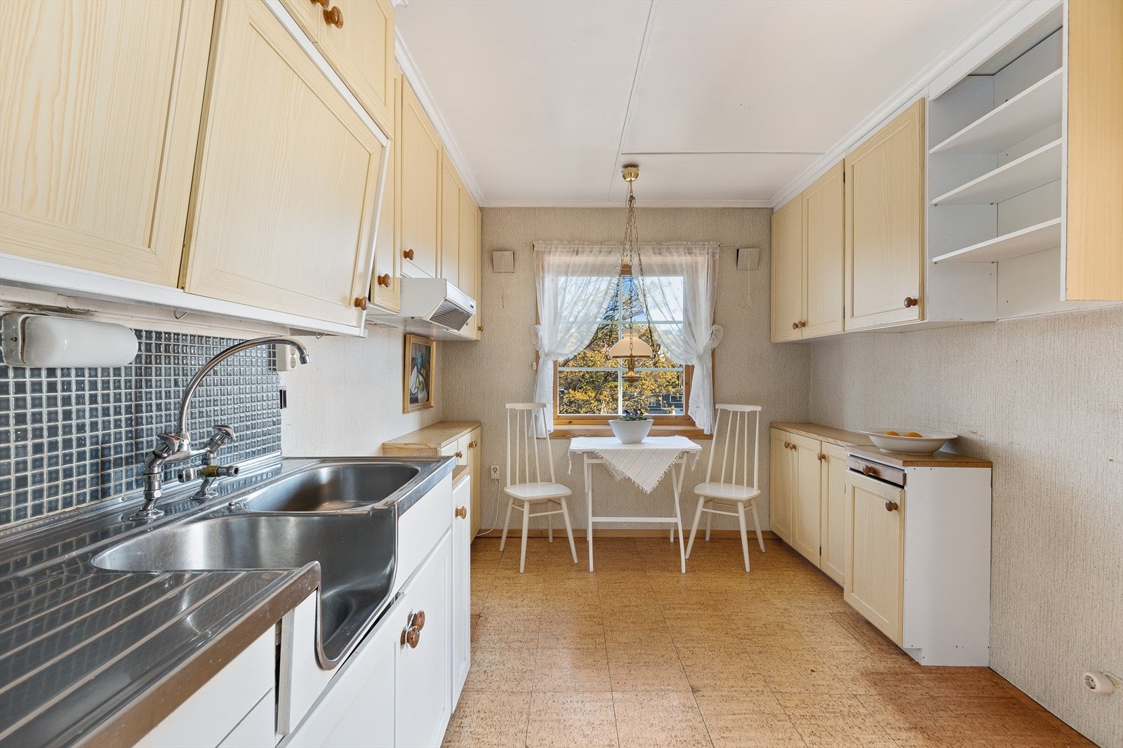 Kjøkkenet har plass til et lite spisebord ved vinduet. Galleribilde