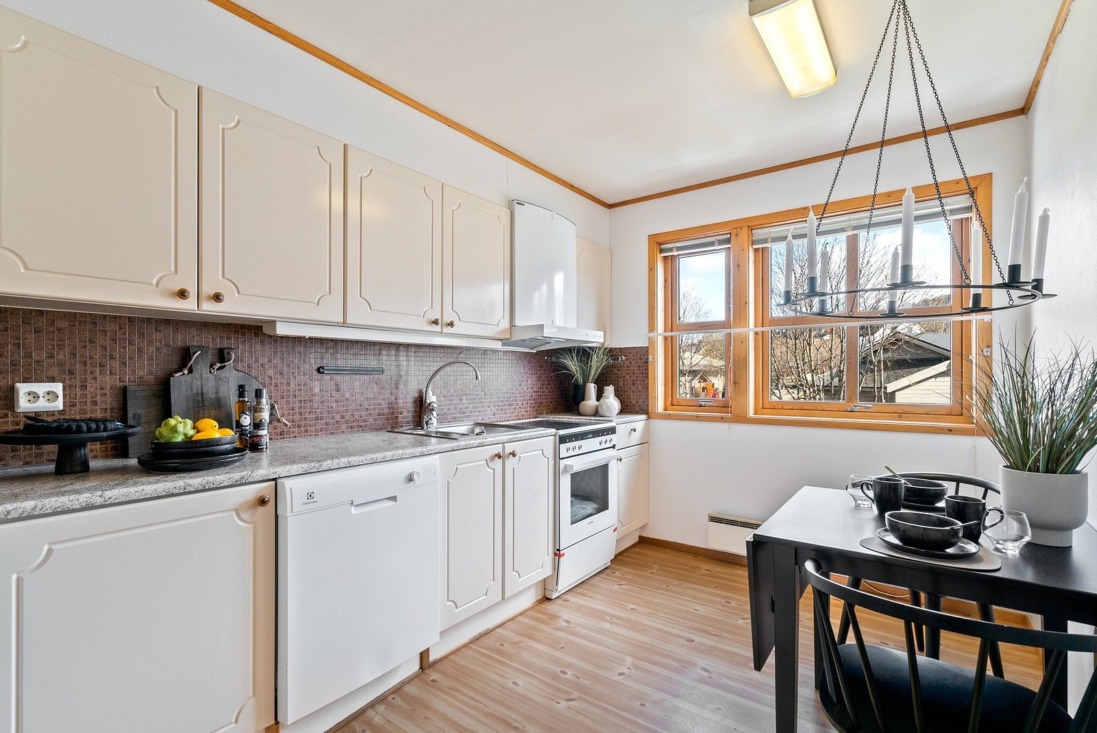 Kjøkken med malte fronter og folierte skrog, laminat benkeplate med rustfritt benkebeslag. Galleribilde