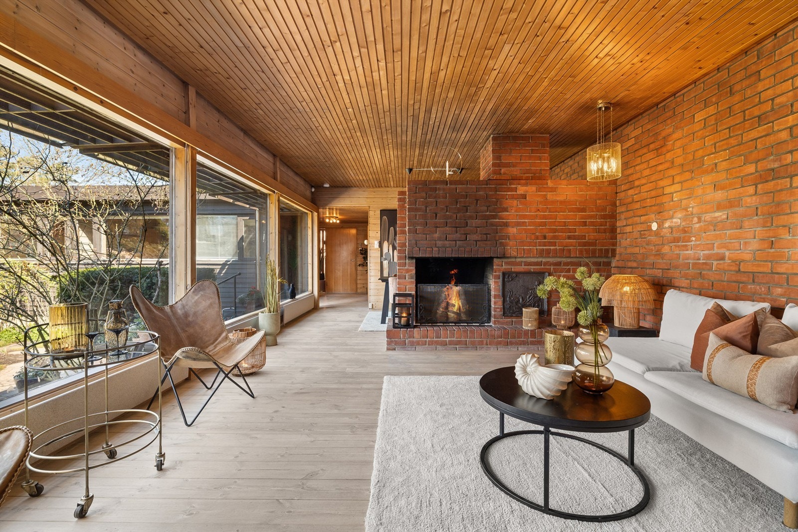 Stue med peis, god takhøyde og store vindusflaer mot atriet Galleribilde