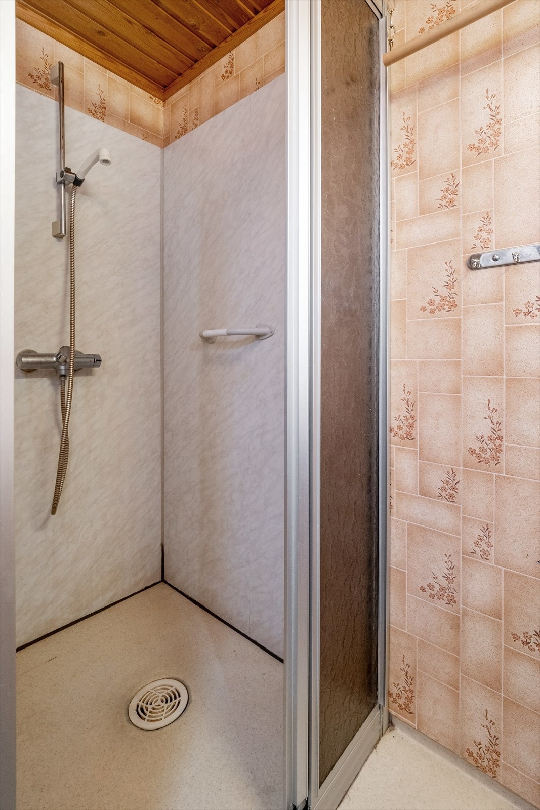 Rommet er innredet med servant montert i skapinnredning med laminert benkeplate, speil og veggskap. Det er også etablert en dusjkrok med plater på veggene og skyvedør. Badet har naturlig avtrekk, og ventil i himling. Galleribilde