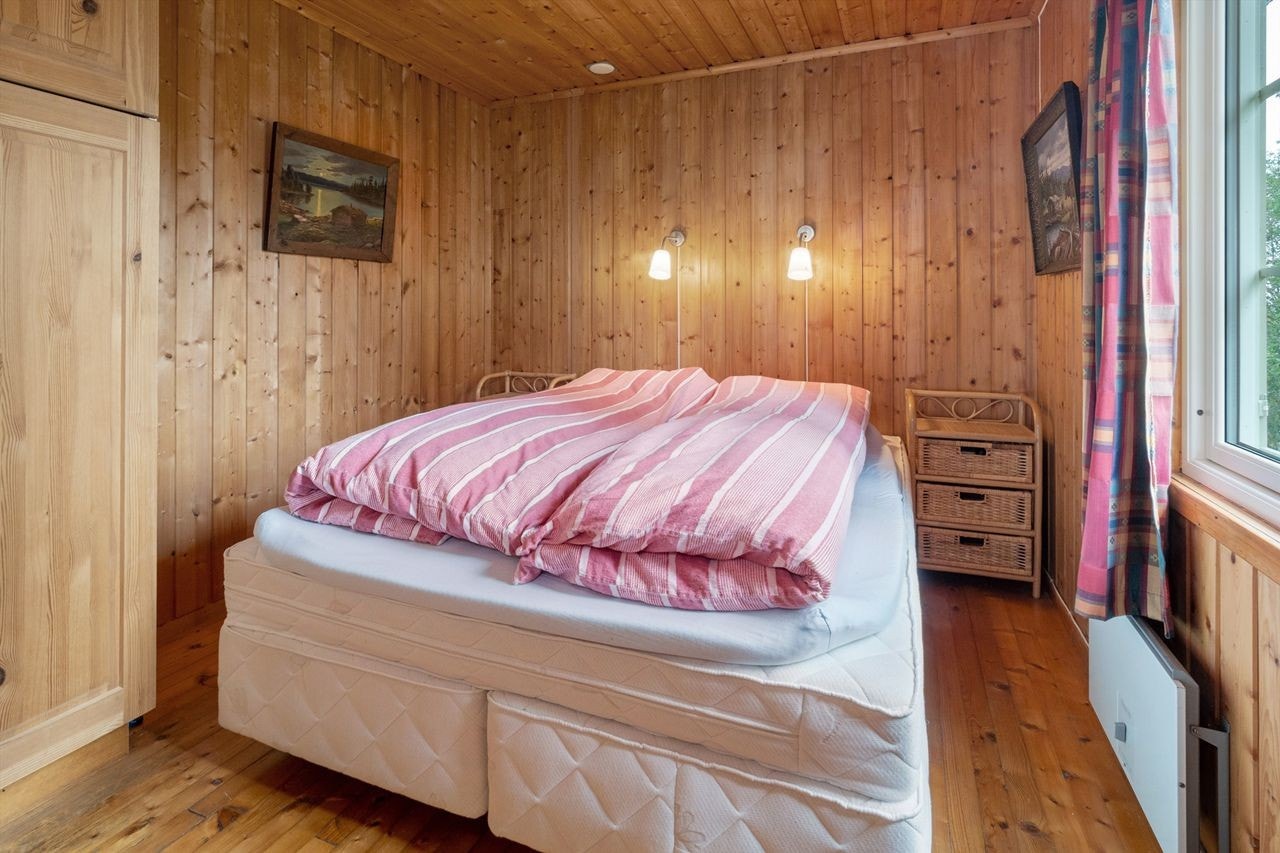 Det andre soverommet har også panel på vegger og i himling, samt tregulv. Rommet er romslig, og etablert med dobbeltseng og garderobeskap. Panelovn montert på vegg som varmekilde. Galleribilde