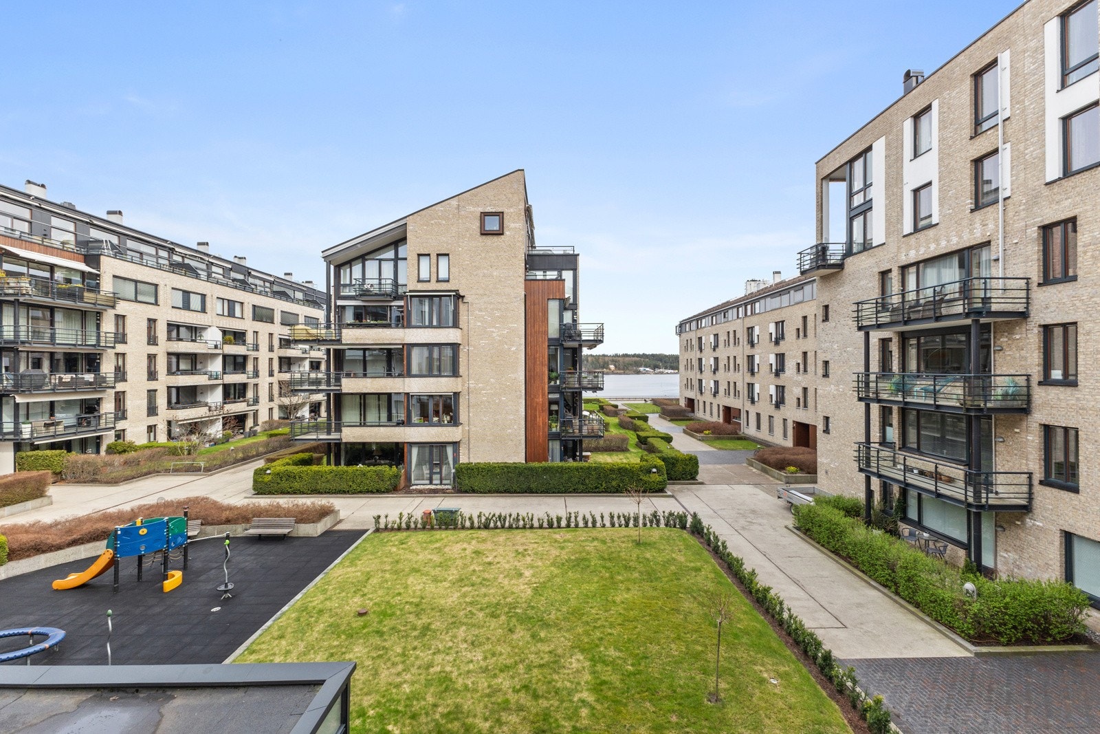 Fellesområde har sittegrupper og grøntarealer med busker og beplantning. Adkomstveier og internveier med asfalt og brostein til inngangspartier. Galleribilde