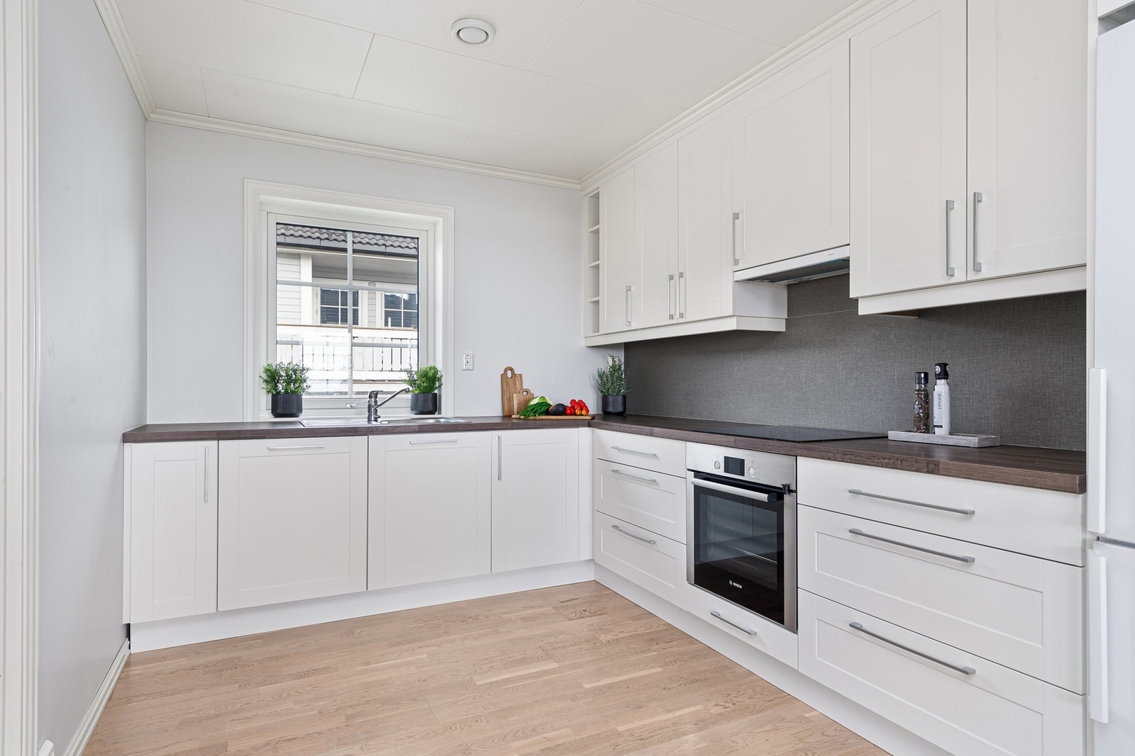 Lyst og fint kjøkken med integrert kjøl/fryseskap, platetopp og komfyr. Galleribilde