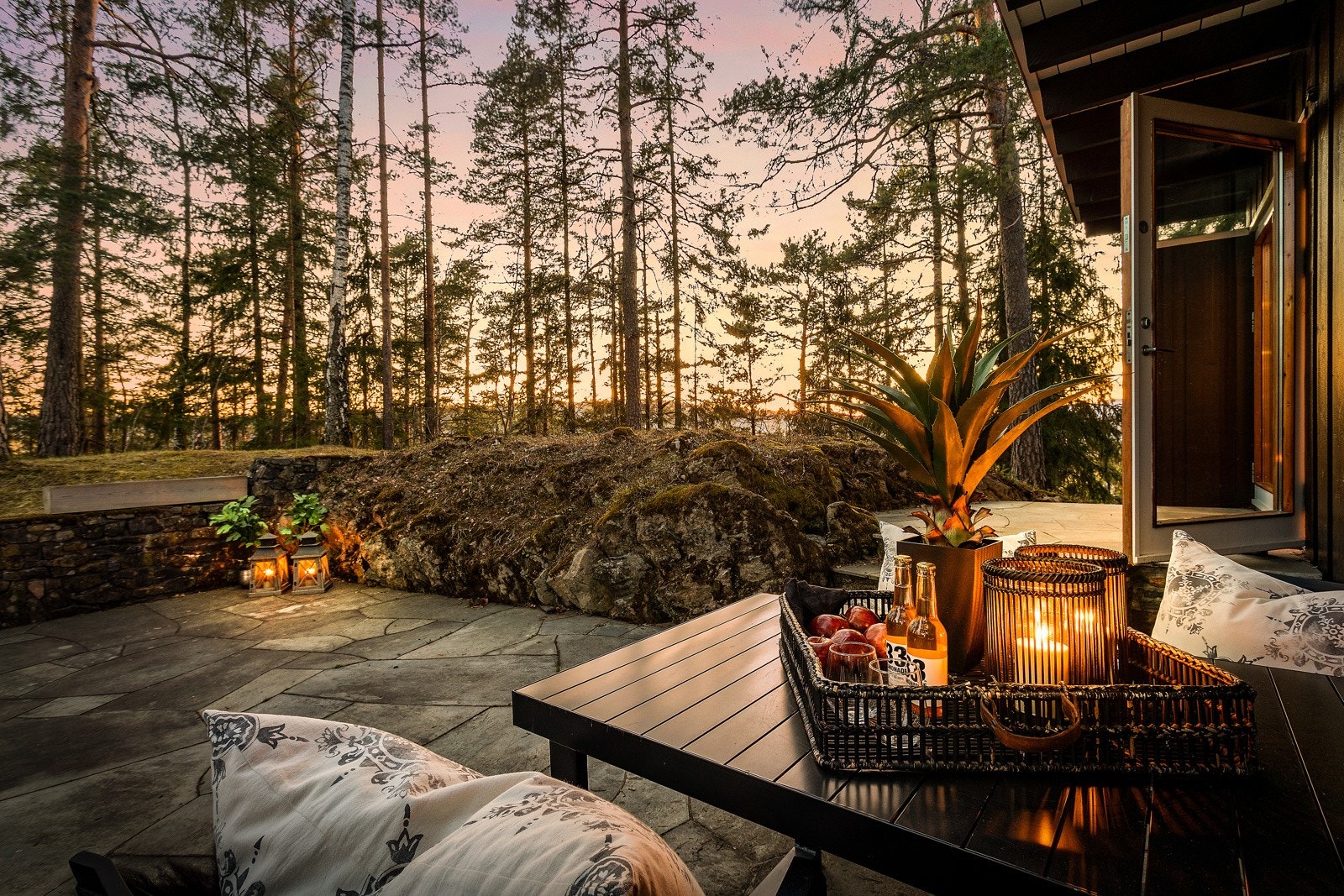 Nydelig utsikt mot skog og kveldshimmel fra skiferlagt terrasse. Galleribilde