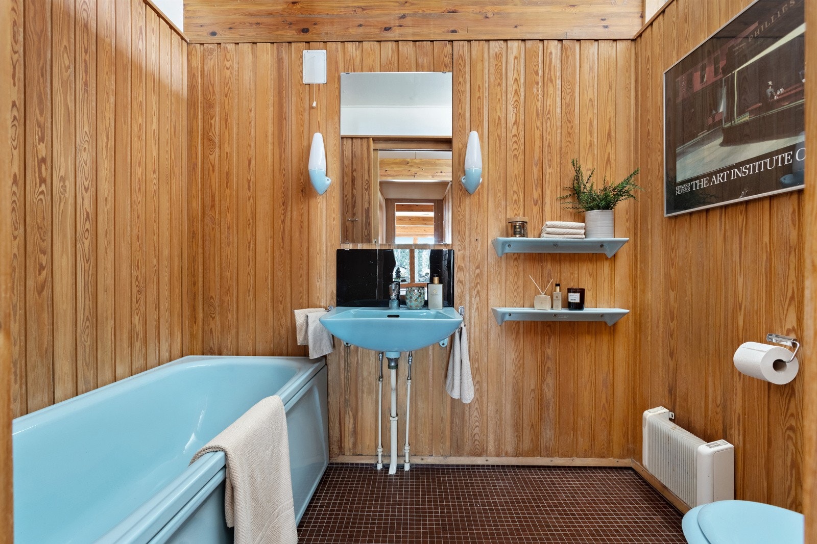 Baderom fra byggeår. Flislagt gulv og vegger i trepanel. Himlingsflater er malte. Vegghengt servant og speil/belysning på vegg. Galleribilde