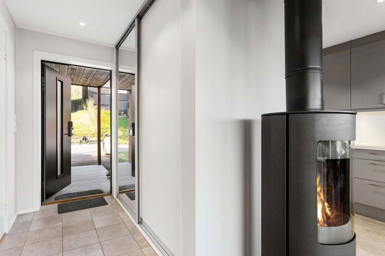 Praktisk entré med flislagt gulv med varmekabler, skyvedørsgarderobe for yttertøy og direkte adkomst til bad Galleribilde