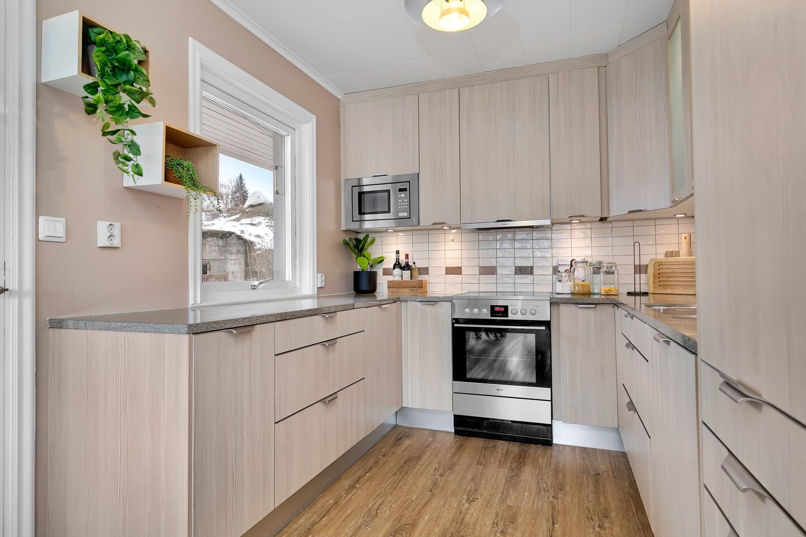 Nyere kjøkkeninnredning med integrert kjøl/fryseskap, oppvaskmaskin og micro. Galleribilde