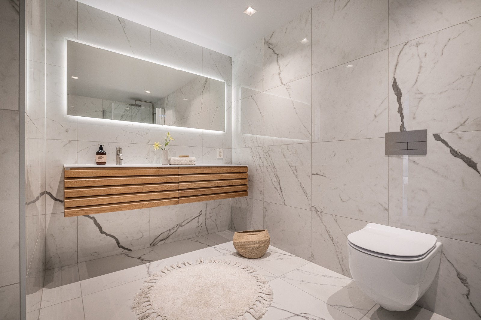 Baderomsinnredning fra den norske kvalitetsleverandøren Linn bad med fronter i heltre eik og heldekkende servant i corian. Galleribilde