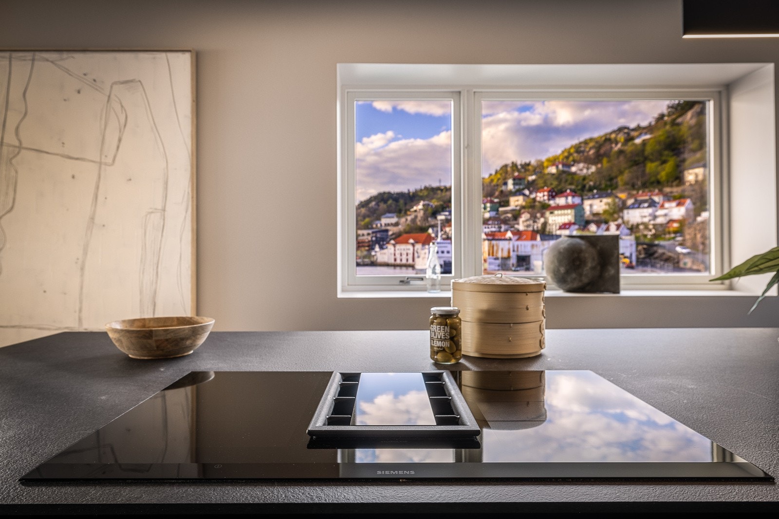 Kjøkkenet har induksjonsplatetopp med integrert ventilator slik at man skal kunne nyte utsikten til det fulle når man lager mat. Galleribilde