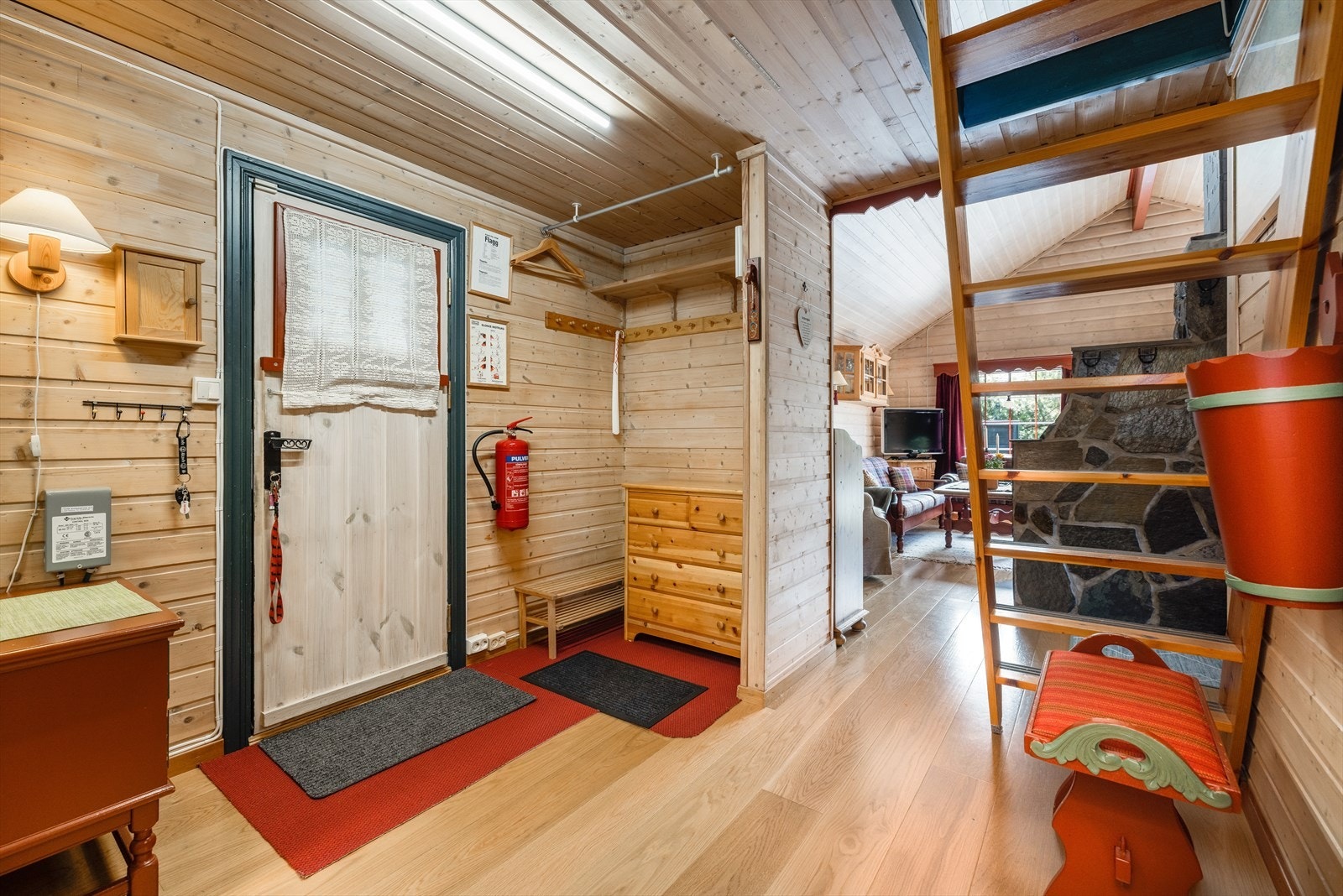 Hyggelig entré inn i hytta med parkett på gulv som er gjennomgående inn til stue/kjøkken. Panel på vegger og i himling. Galleribilde