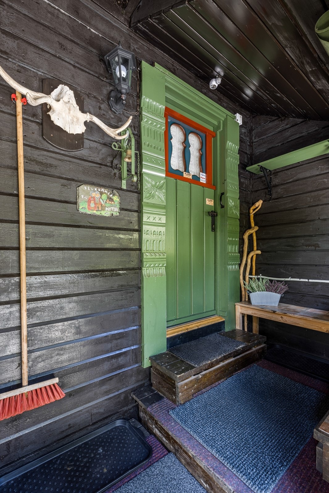 Inngangen til hytta under takoverbygd, liten veranda. Galleribilde