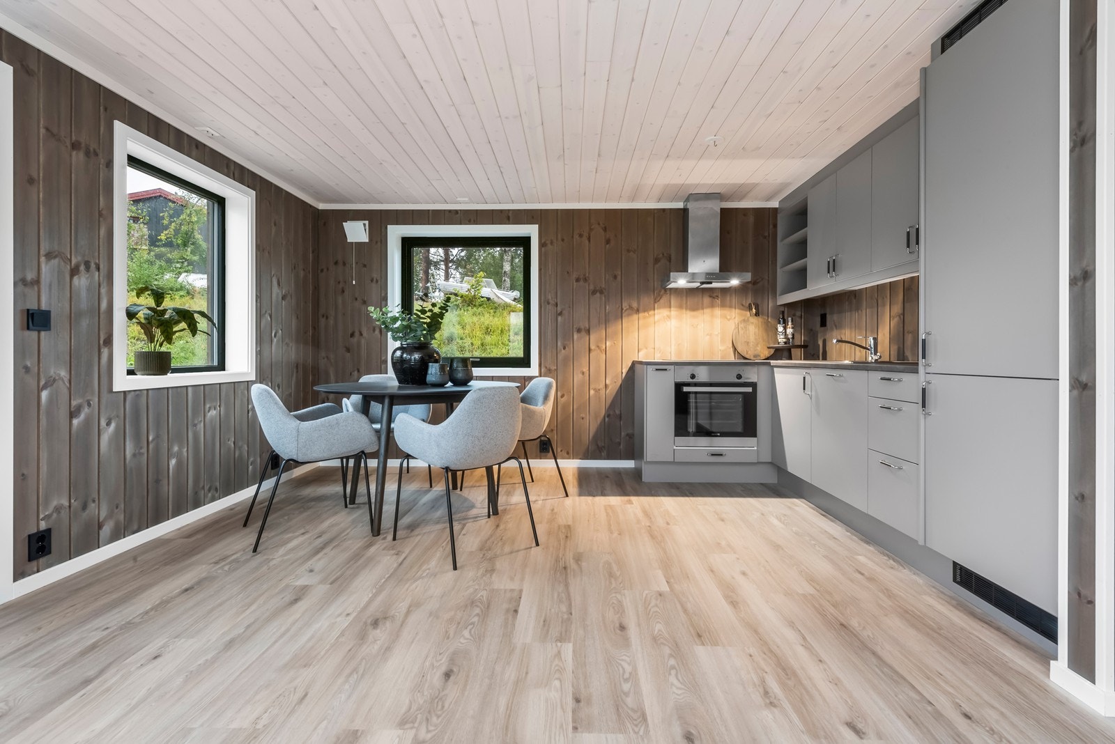 Moderne kjøkkeninnredning med integrert oppvaskmaskin, stekeovn, platetopp og kombi kjøl/frys. Galleribilde