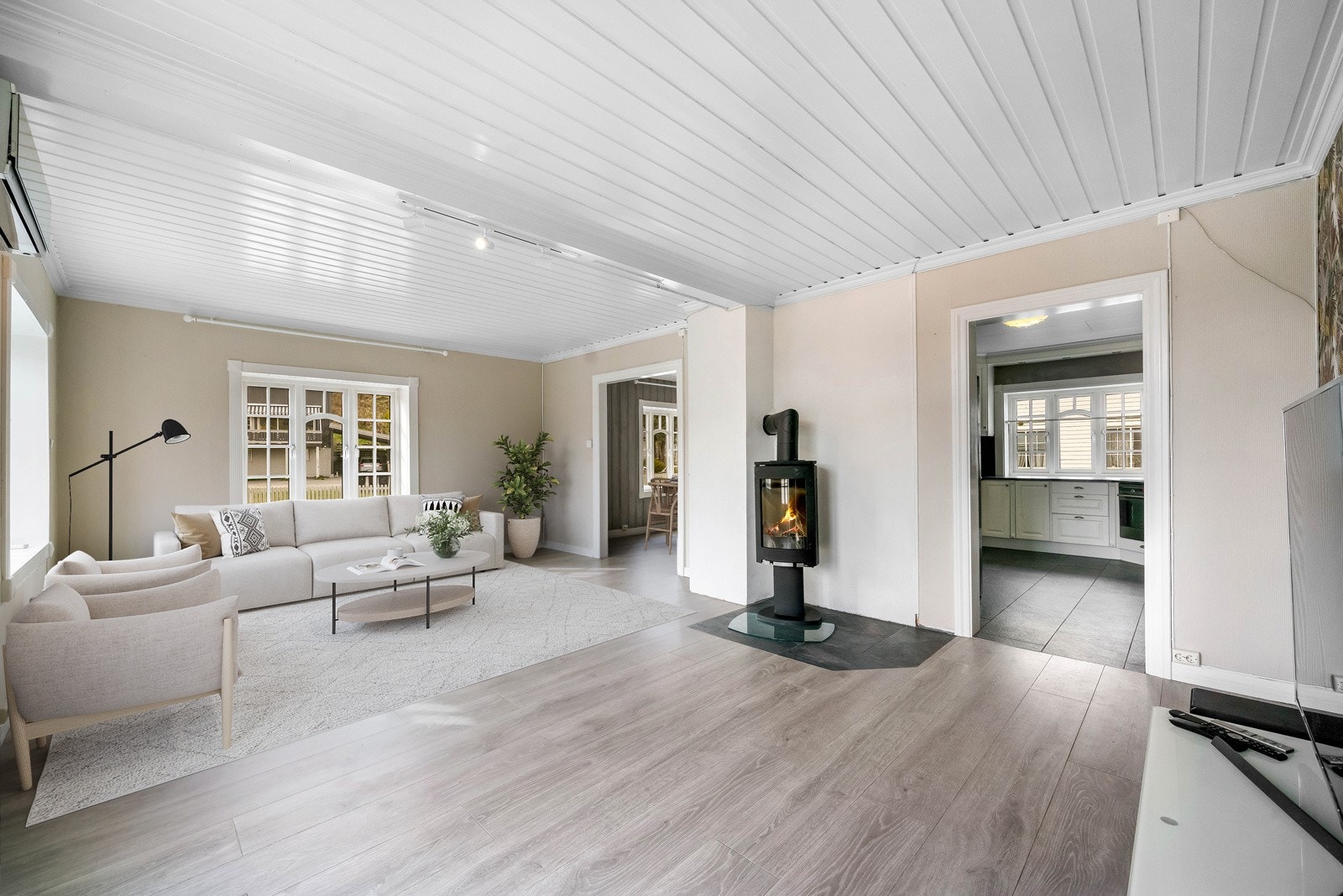 Stua er utstyrt med flere store vinduer som slipper inn mye lys. Utgang fra stue til terrasse via doble glassdører med pen utsmykking. Rommet har digital styling. Galleribilde