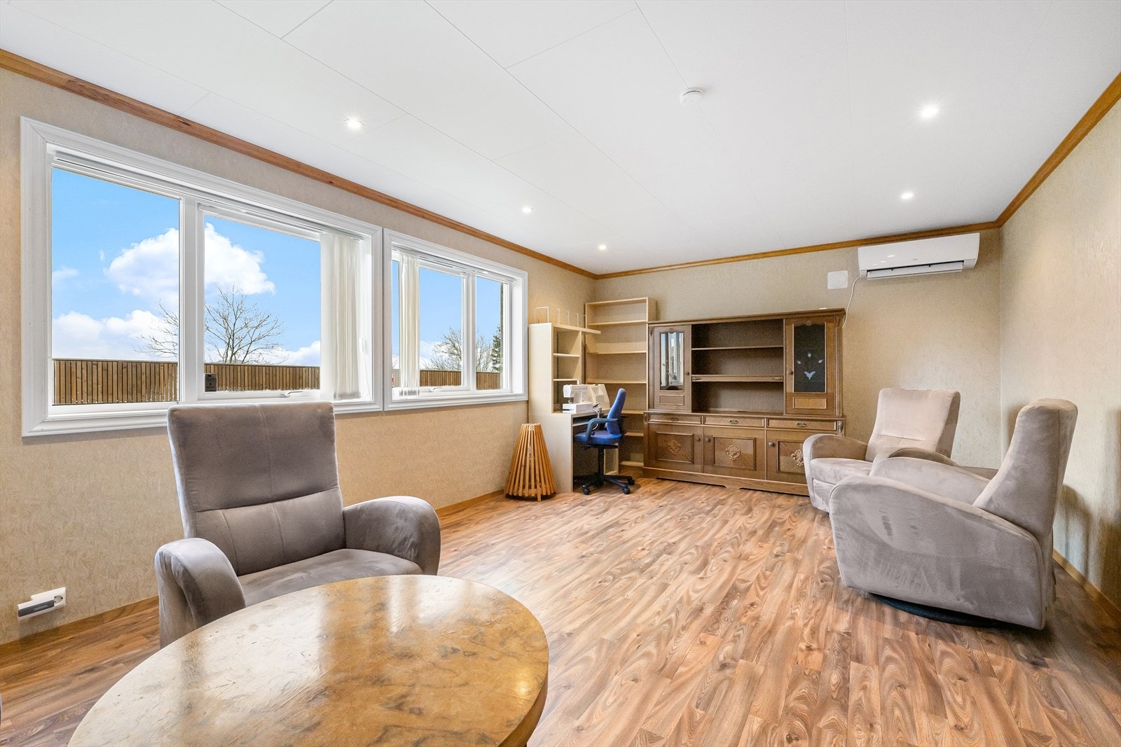 Kjellerstuen er lys og trivelig. Det er innfelte spotter i himlingen og en luft-til-luft varmepumpe. Galleribilde