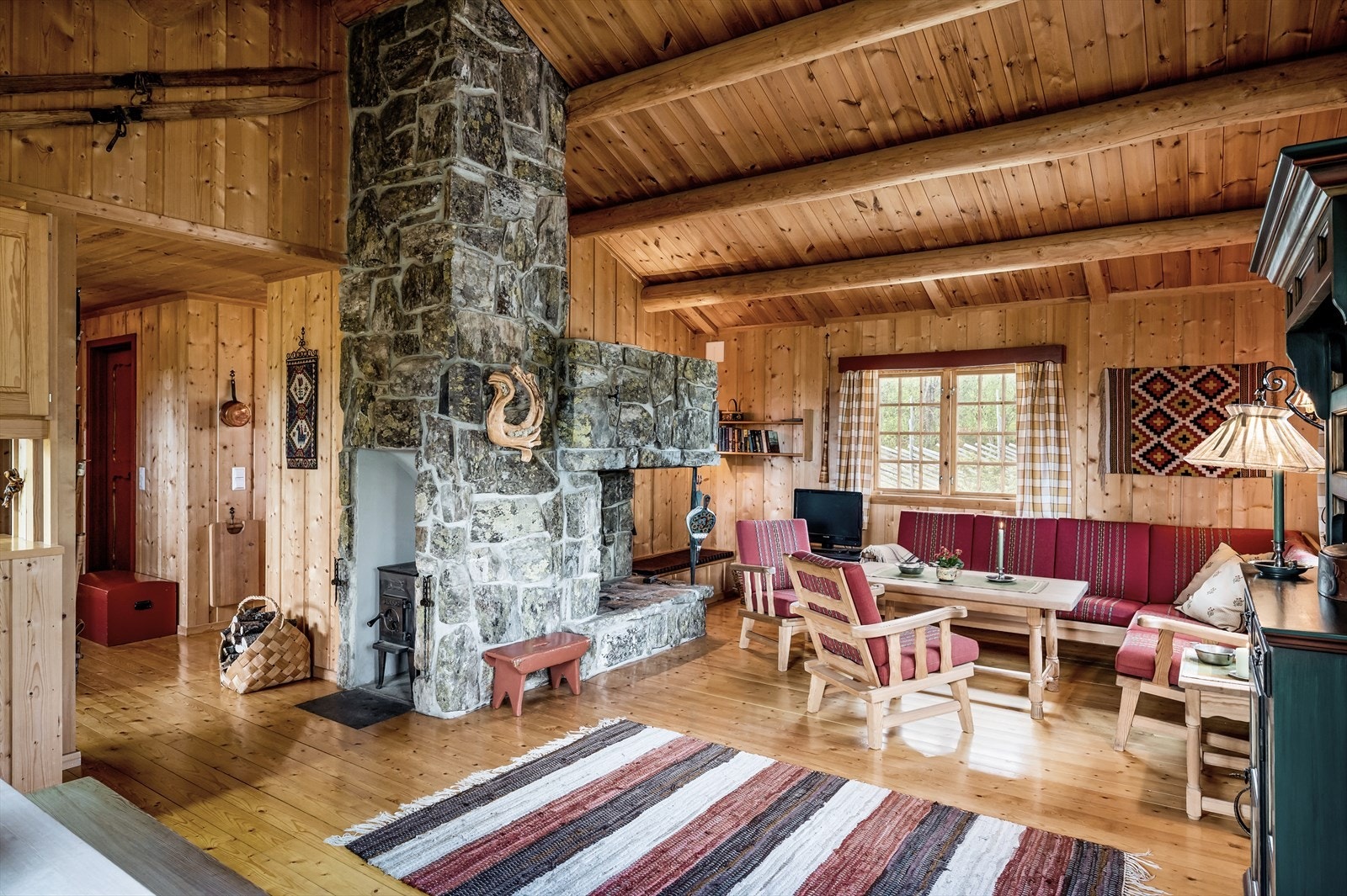 I stuen er det åpne peis forblendet med naturstein. Vedovn i innebygd nisje ved siden av. Galleribilde