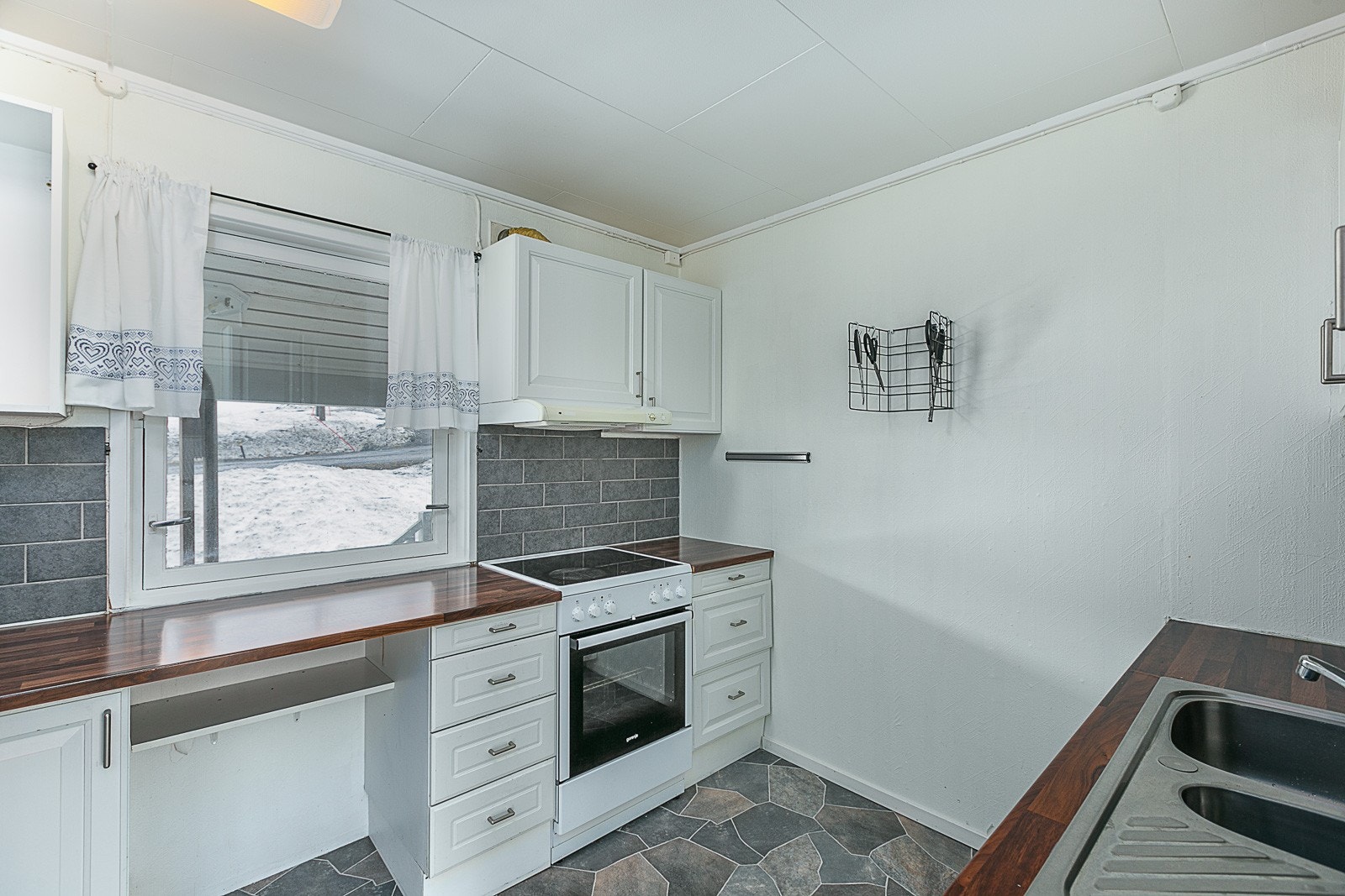 Eldre kjøkkeninnredning med avsatt plass til hvitevarer. Galleribilde