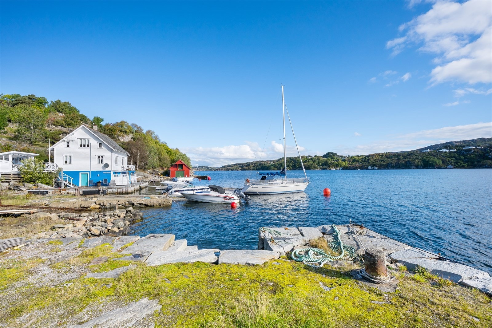 Området består av naust og bebyggelse og fremstår som et idyllisk sted på fine sommerdager Galleribilde