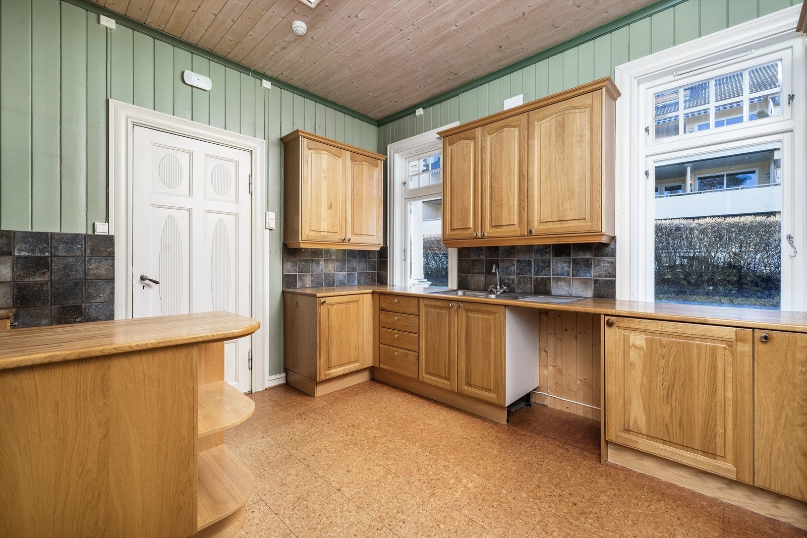 Kjøkkeninnredning fra starten av 2000 tallet med fronter i lakkert eik og lakkert eik benkeplate. Galleribilde