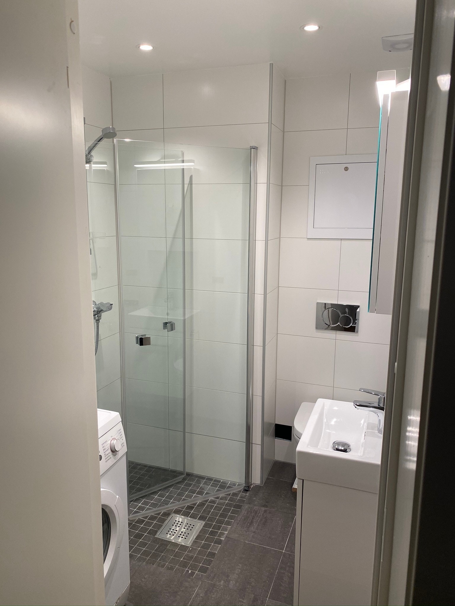 Helt nytt flislagt dusjbad med vaskemaskin installert. Galleribilde