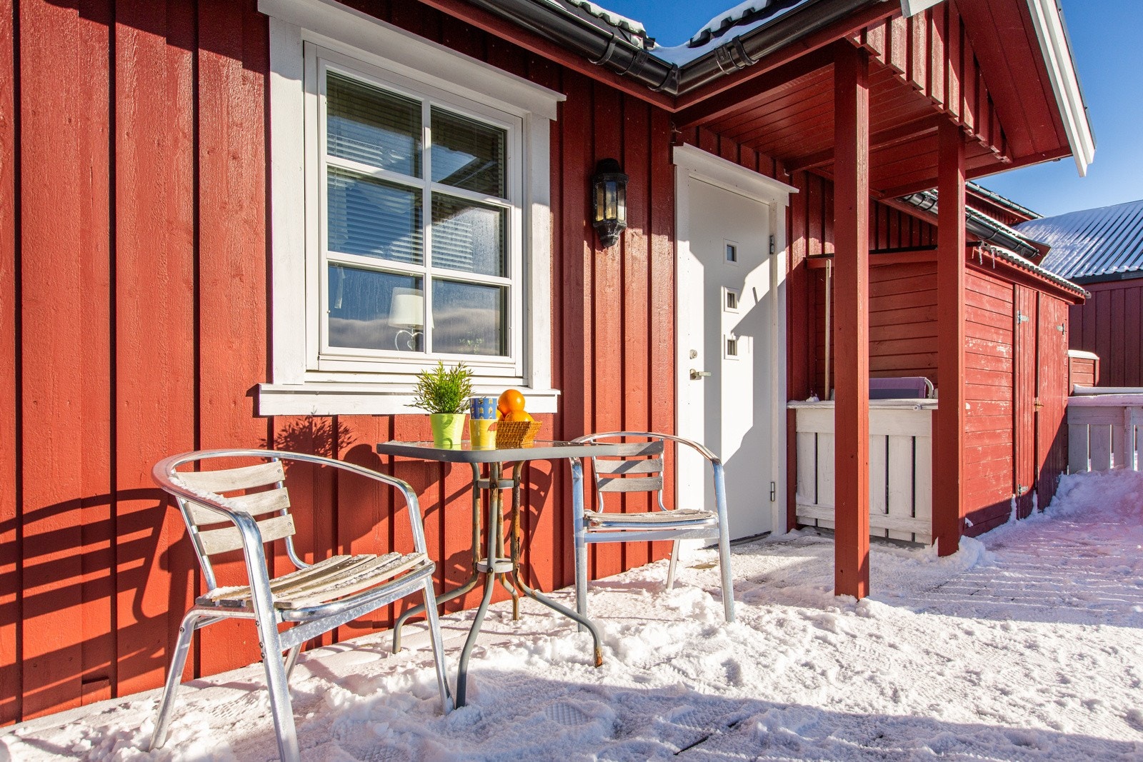 Utebod ved siden av inngangsdøra og hyggelig platting med plass for hagemøbler Galleribilde