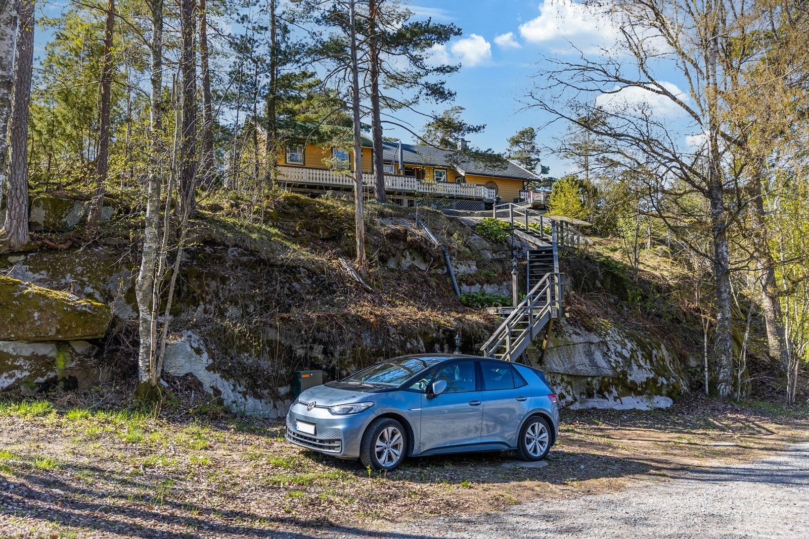 Nedenfor hytta er det en biloppstillingsplass med trapp opp til selve tomten. Galleribilde