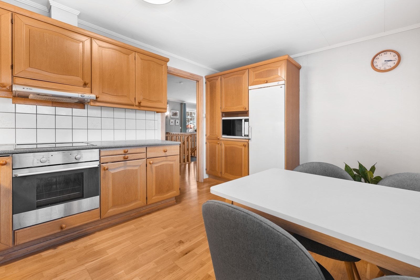 Kjøkkenet har profilerte fronter med heltre av eik. Laminat benkeplate, rustfritt nedfelt beslag med vask. Galleribilde