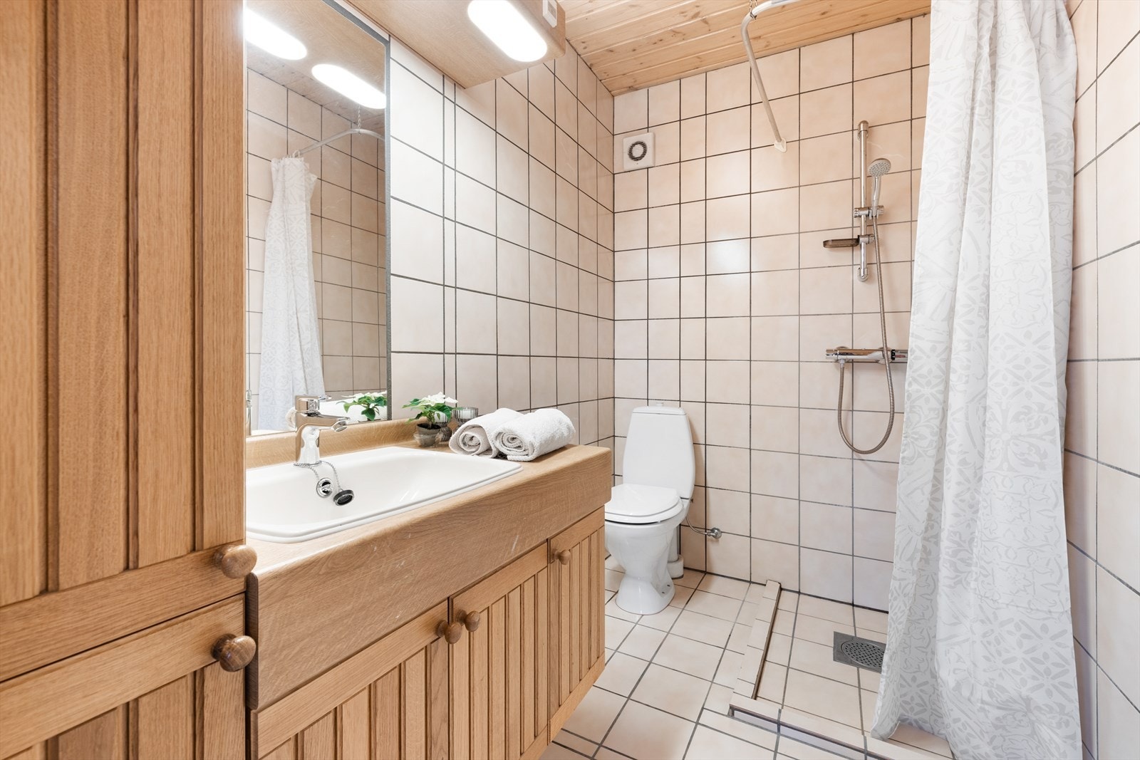 Badet i u.etg består av dusjnisje, gulvstående toalett og servant i innredning med høyskap. Varmekabler i gulv følger på begge bad. Galleribilde