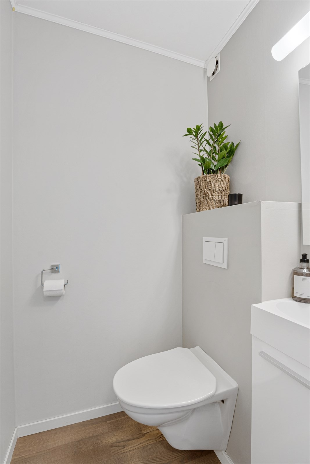 Separat WC som inneholder vegghengt toalett og innredning med vask og speil. Galleribilde