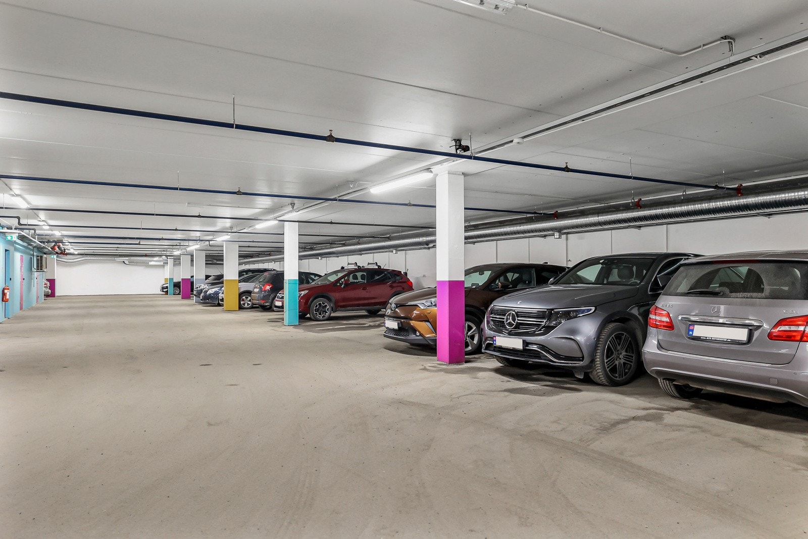 Parkeringsplass med elbil lader i felles garasjeanlegg Galleribilde