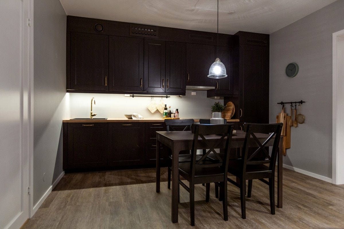 Kjøkkenet har integrerte hvitevarer; keramisk platetopp, stekeovn, oppvaskmaskin, kjøl-/fryseskap og avtrekksvifte med kullfilter over kokeplate Galleribilde