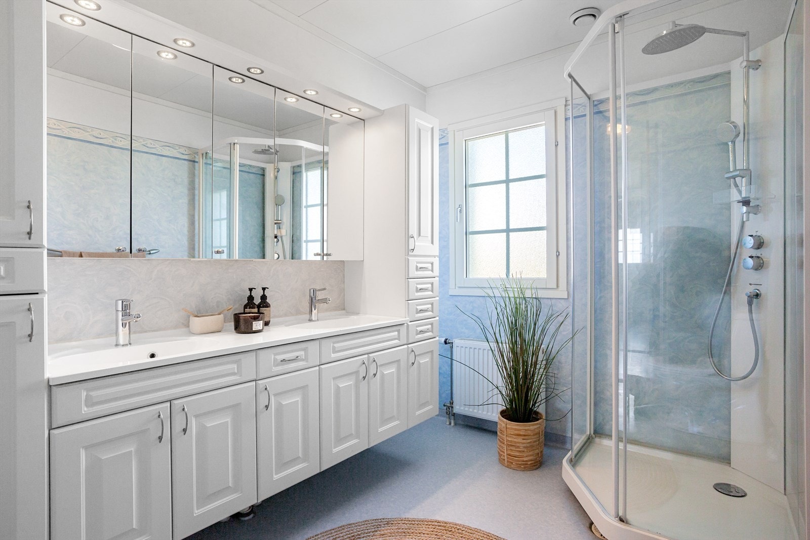 Baderomsinnredningen består av dusjkabinett, servant med to vasker, Galleribilde