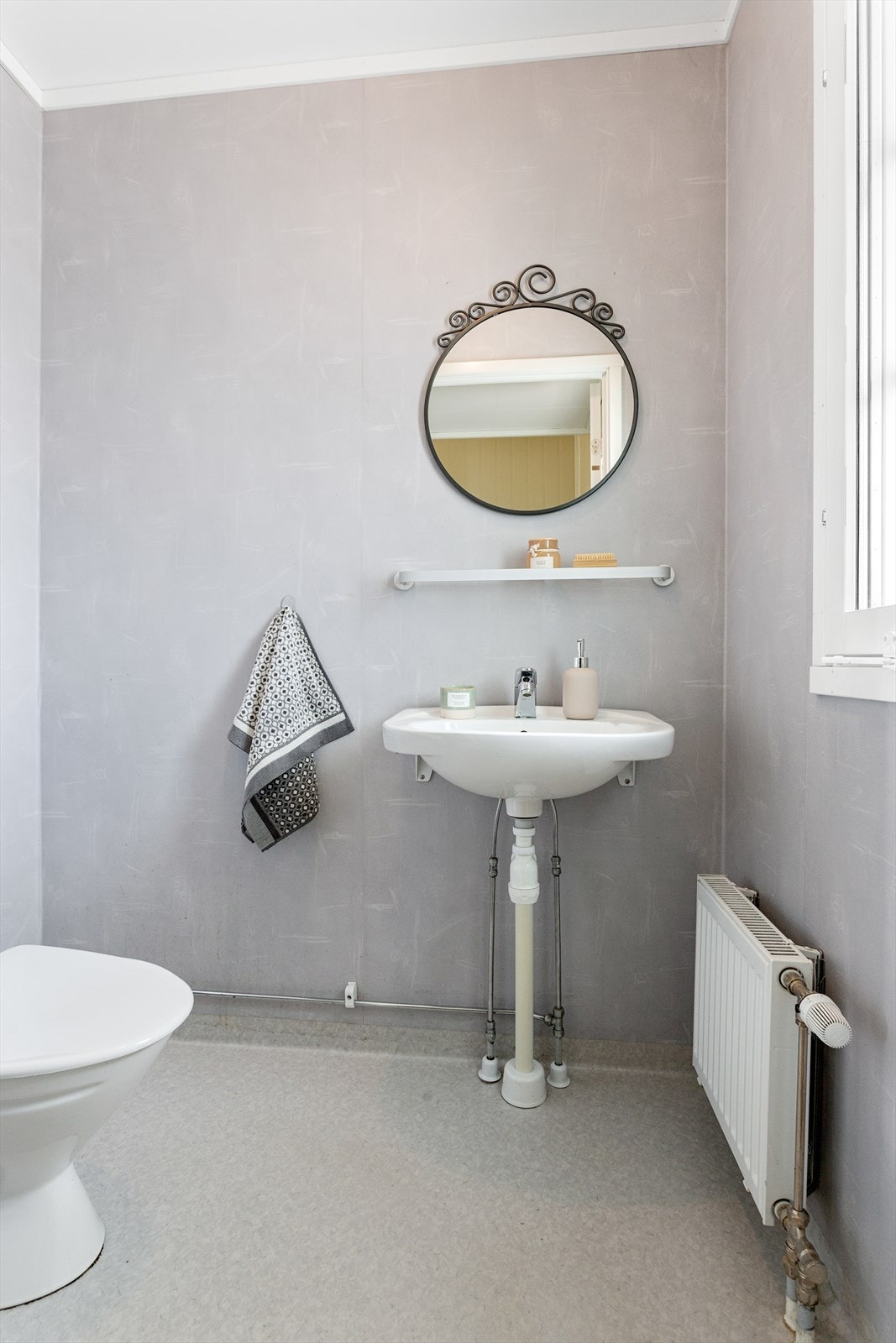 Toalettrom ved inngangen med servant og toalett. Våtromsbelegg på vegger og gulvet. Galleribilde