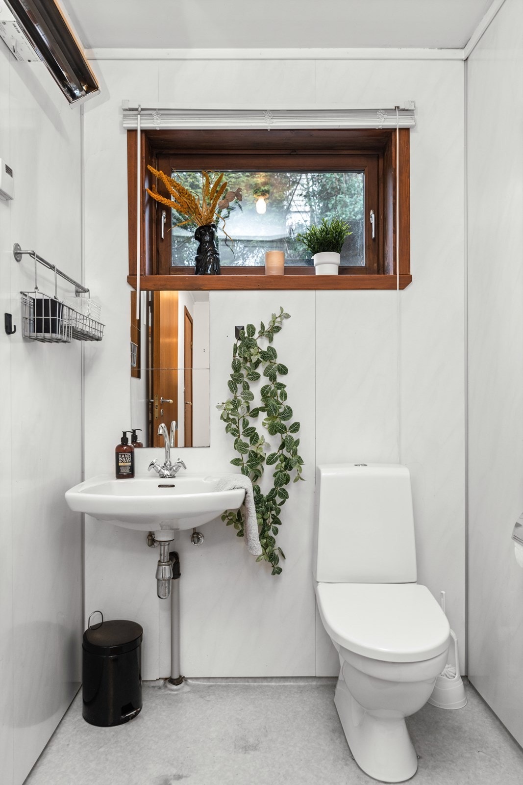 Bad med enkel servant, wc og dusj på gulv. Galleribilde