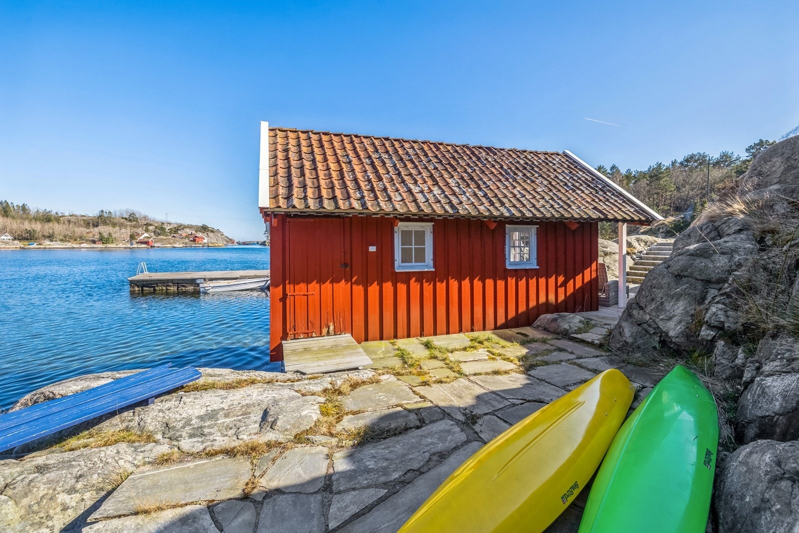 Baksiden av sjøbua med platting og inngang til boden Galleribilde