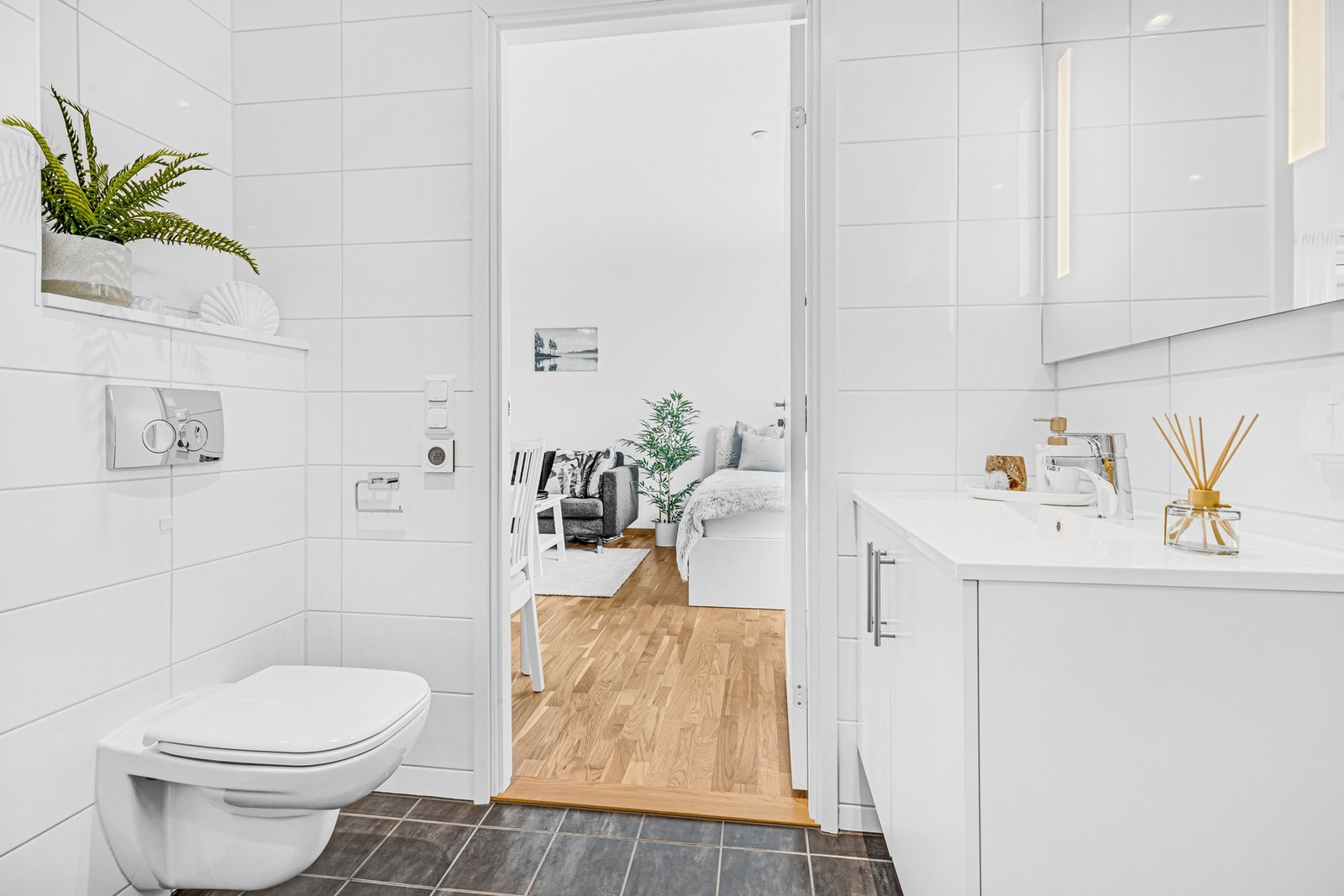 Badet er innredd med bl.a. dusjkabinett, veggmontert WC, servant med skap. Galleribilde