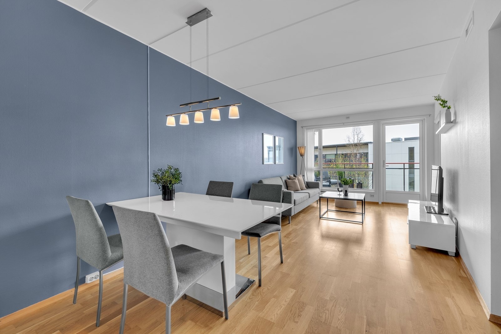 Stuen er lys og det er god plass til både sofa og spisestuemøbler. Store vindusflater mot sørvest. Galleribilde