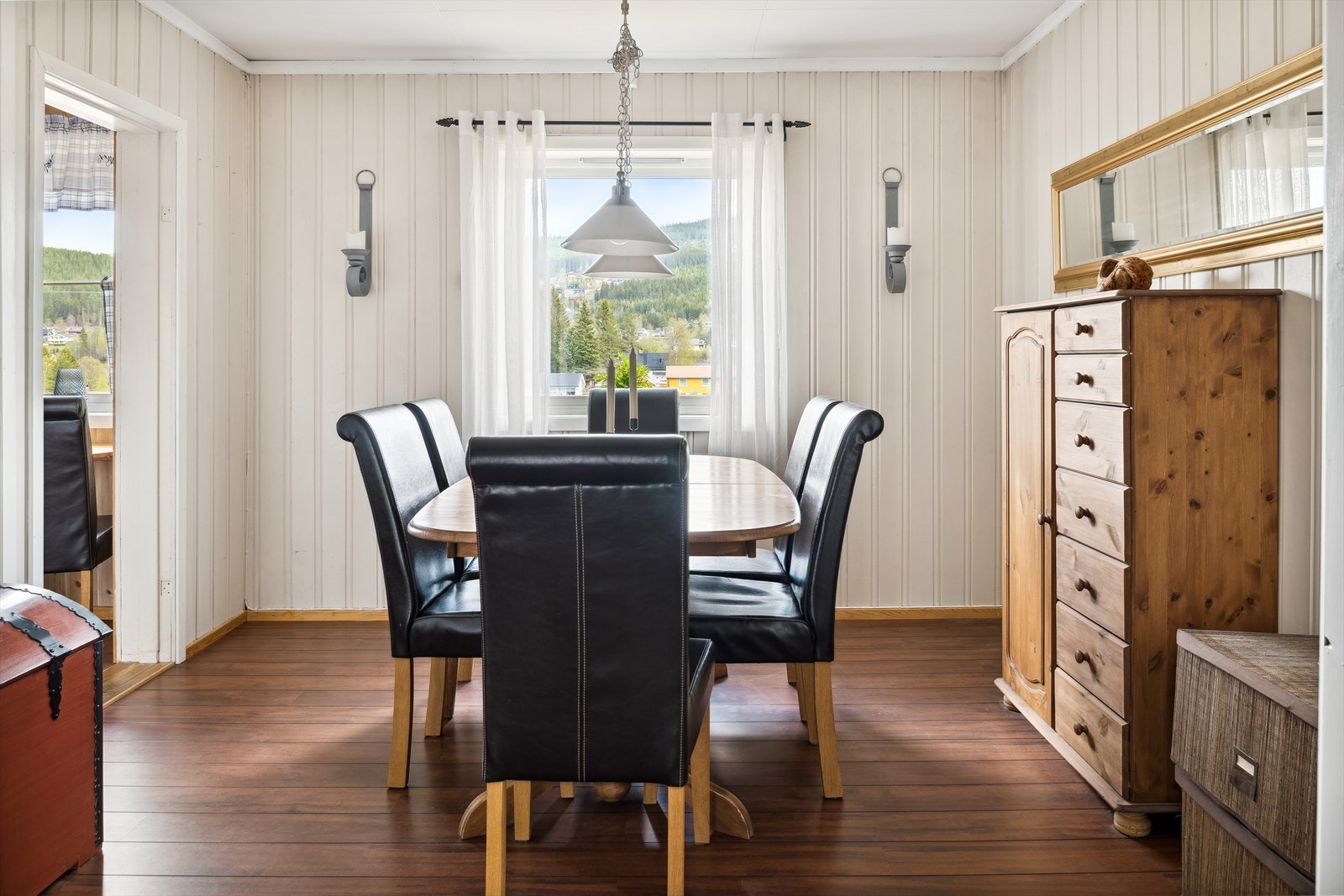 Fra mellomstuen har du adkomst til spisestuen som ligger i naturlig tilknytning til kjøkkenet. Spisestuen har laminat på gulv, lysmalt trepanel på veggene og et stort vindu som slipper inn fint lys. Naturlig plass til et stort spisebord. Galleribilde